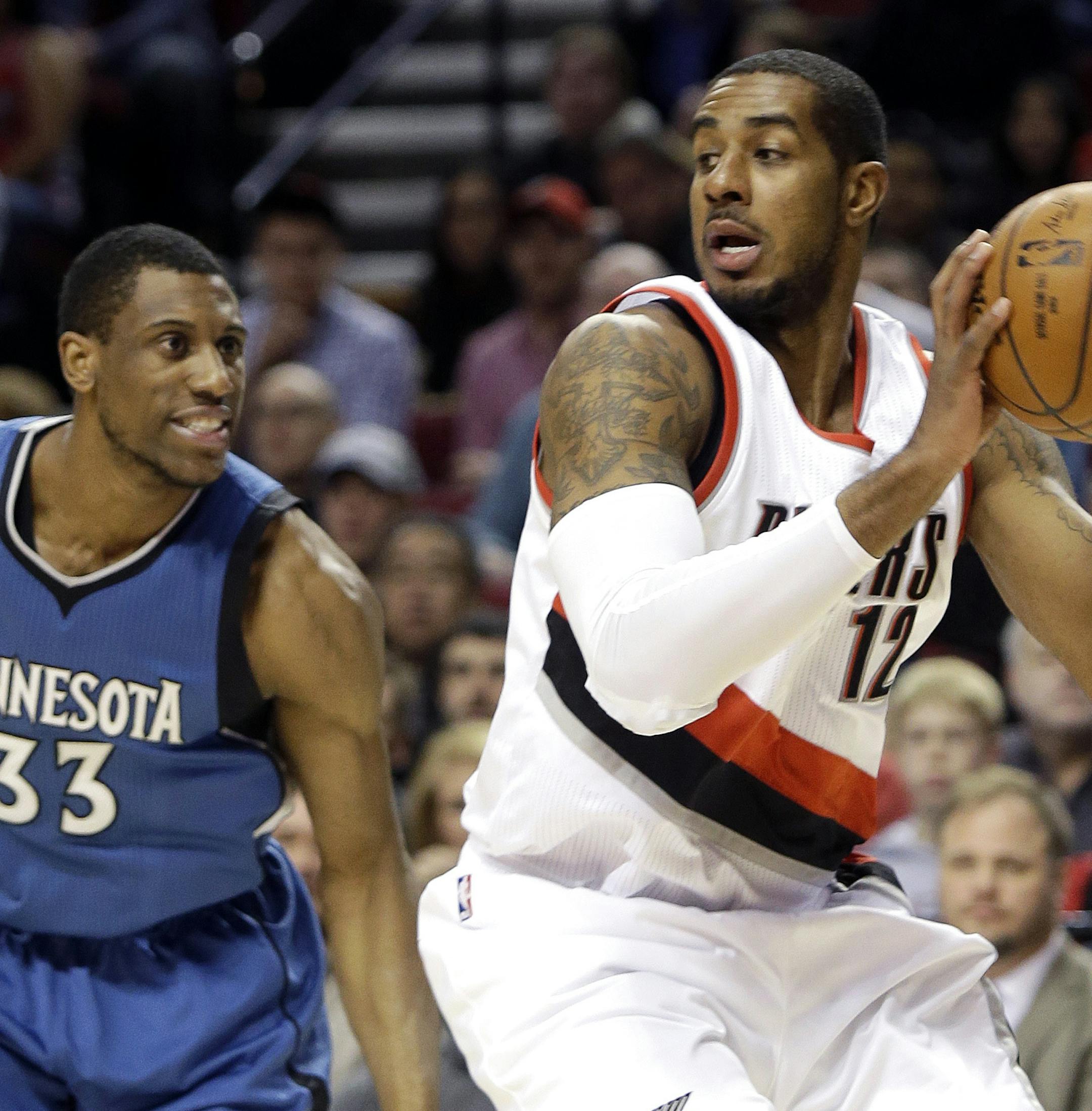 Portland Trail Blazers forward LaMarcus Aldridge looks for an opening as Minnesota Timberwolves forward Thadeus Young, left, defends during the first half of an NBA basketball game in Portland, Ore., Sunday, Nov. 30, 2014. (AP Photo/Don Ryan)