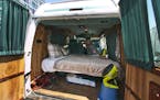 In this Monday, Aug. 3, 2015, photo, Jonathan Powley, who rents parked vehicles on Airbnb, prepares a 1995 Chevrolet conversion van, one of his offeri
