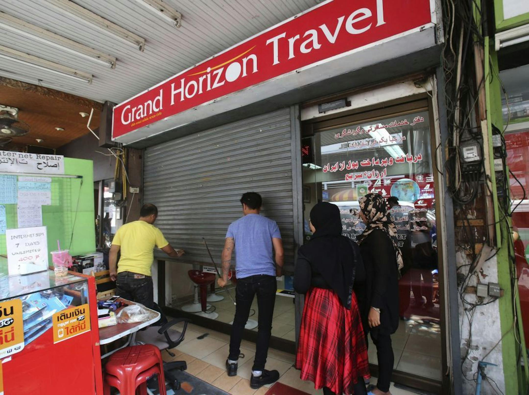 Employees of Grand Horizon Travel close the door of the office in Pattaya, Chonburi province, Thailand on Monday, March 10, 2014.
