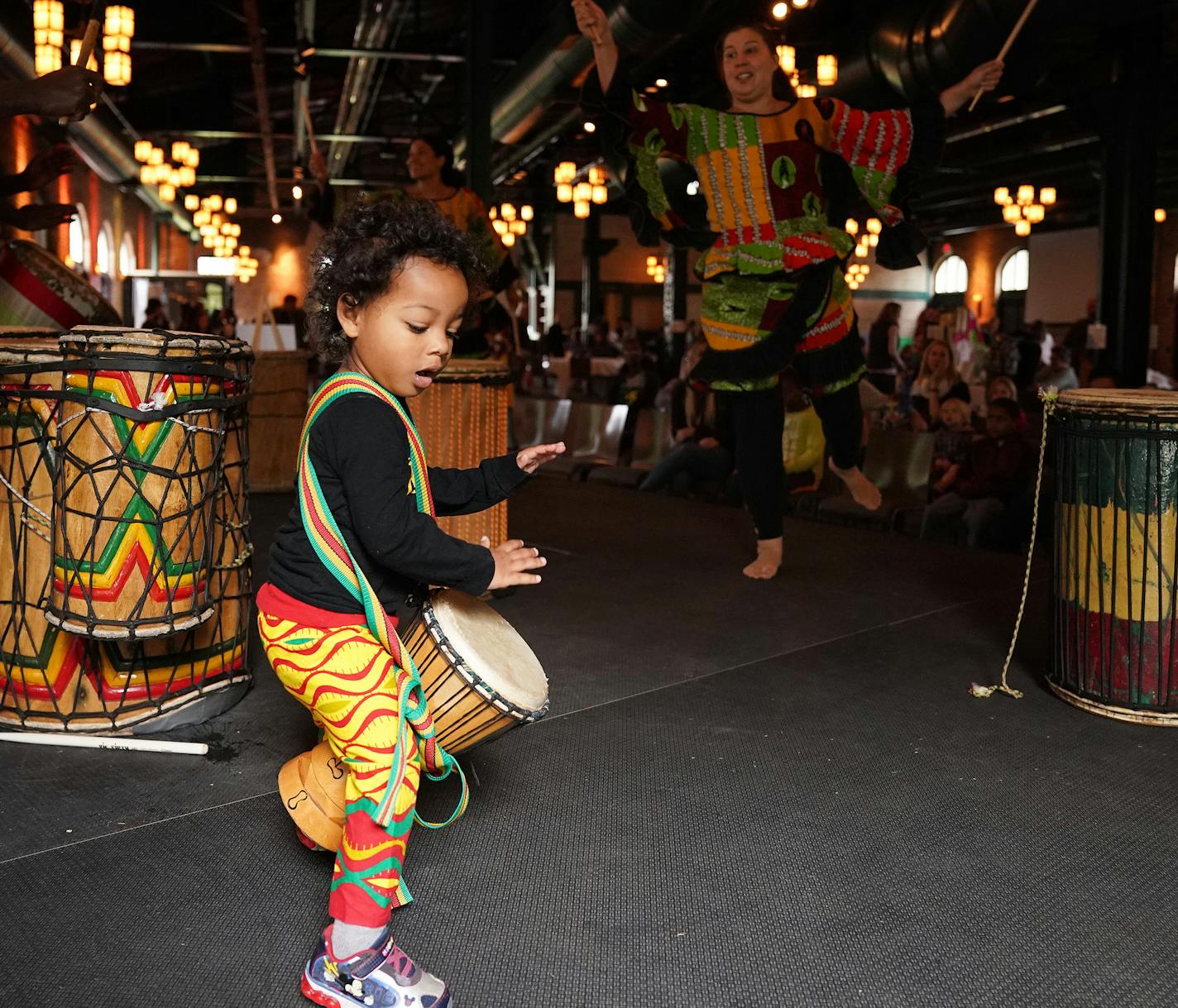 Above, Aboubacar Bangoura, 2, played the drums during a demonstration by Duniya Drum and Dance. Cat toys made from plastic Easter eggs, pasta shells and tape will be donated to Feline Rescue. Josh Ostrowski, with the Teehive, helped attendees make Doing Good Together T-shirts.