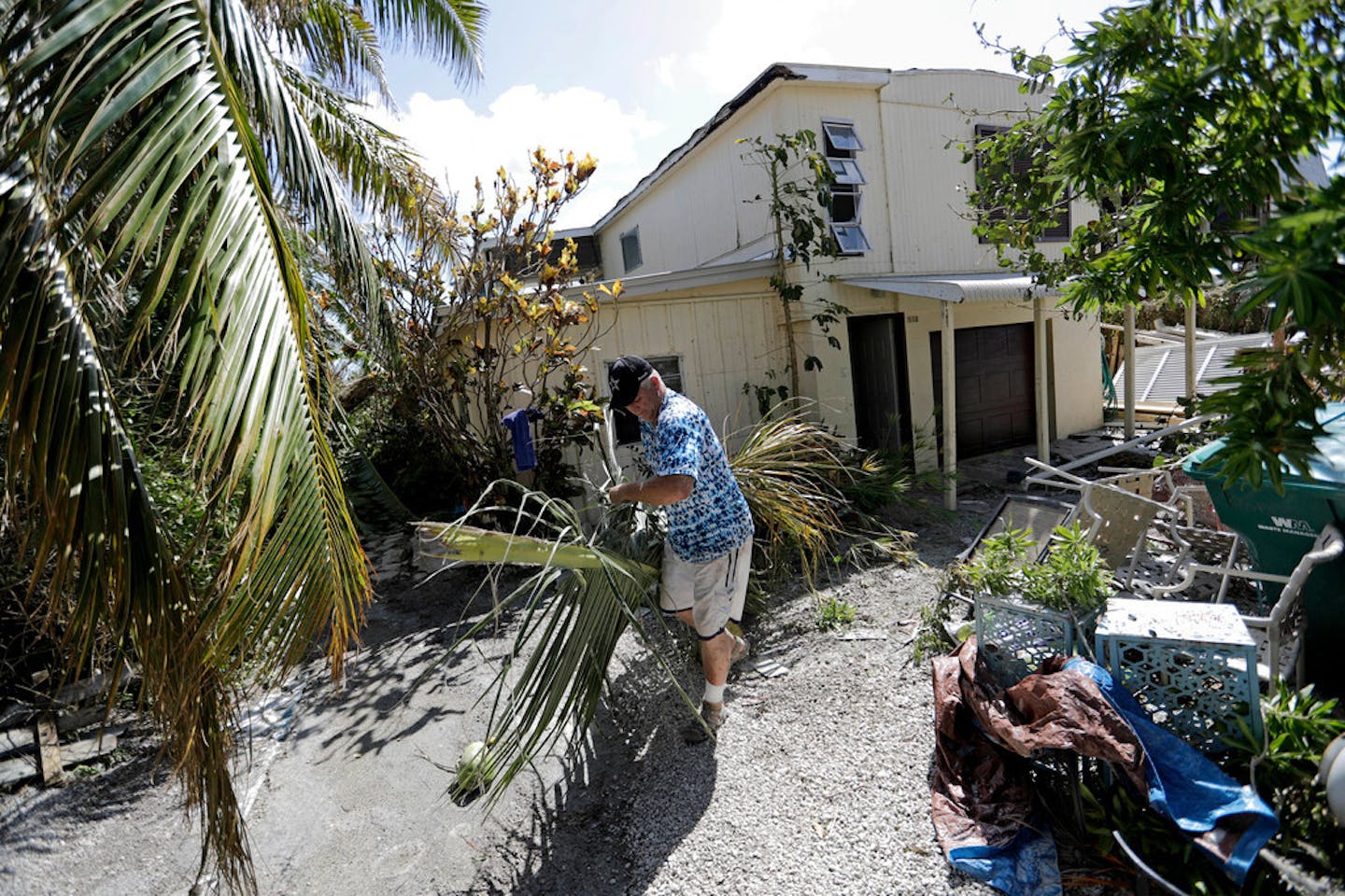 Rob Brehm cleans up debris from his home in the aftermath of Hurricane Irma in Goodland, Fla., Tuesday, Sept. 12, 2017.