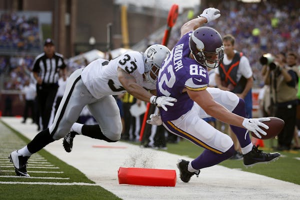 Minnesota Vikings Kyle Rudolph (82) was pushed out of bounds by Tyvon Branch (33) just short of the goal line in the first quarter of an exhibition ga