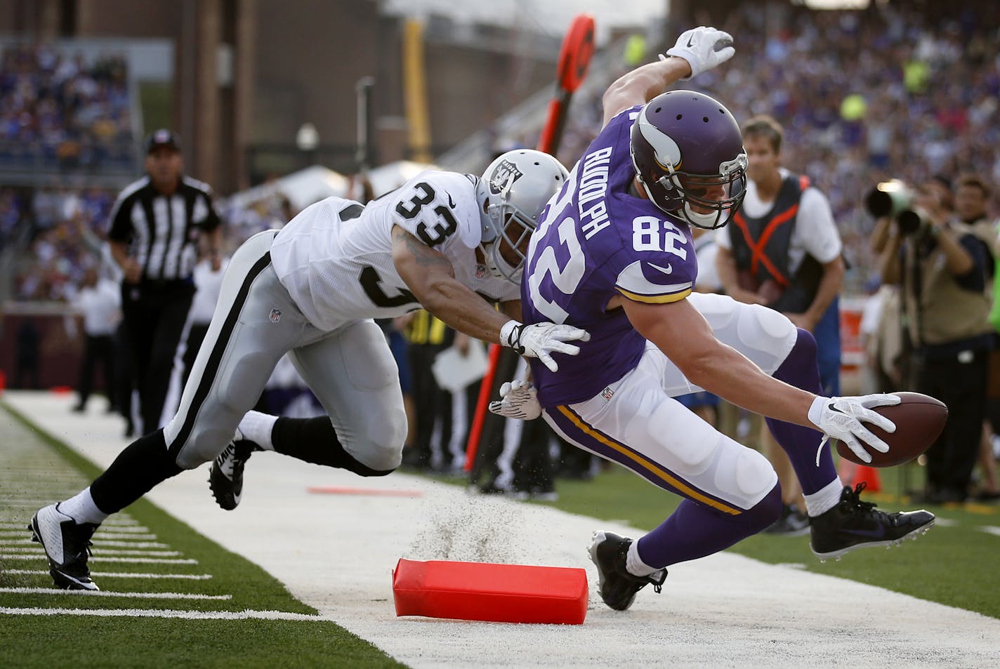 Minnesota Vikings Kyle Rudolph (82) was pushed out of bounds by Tyvon Branch (33) just short of the goal line in the first quarter of an exhibition game in August.