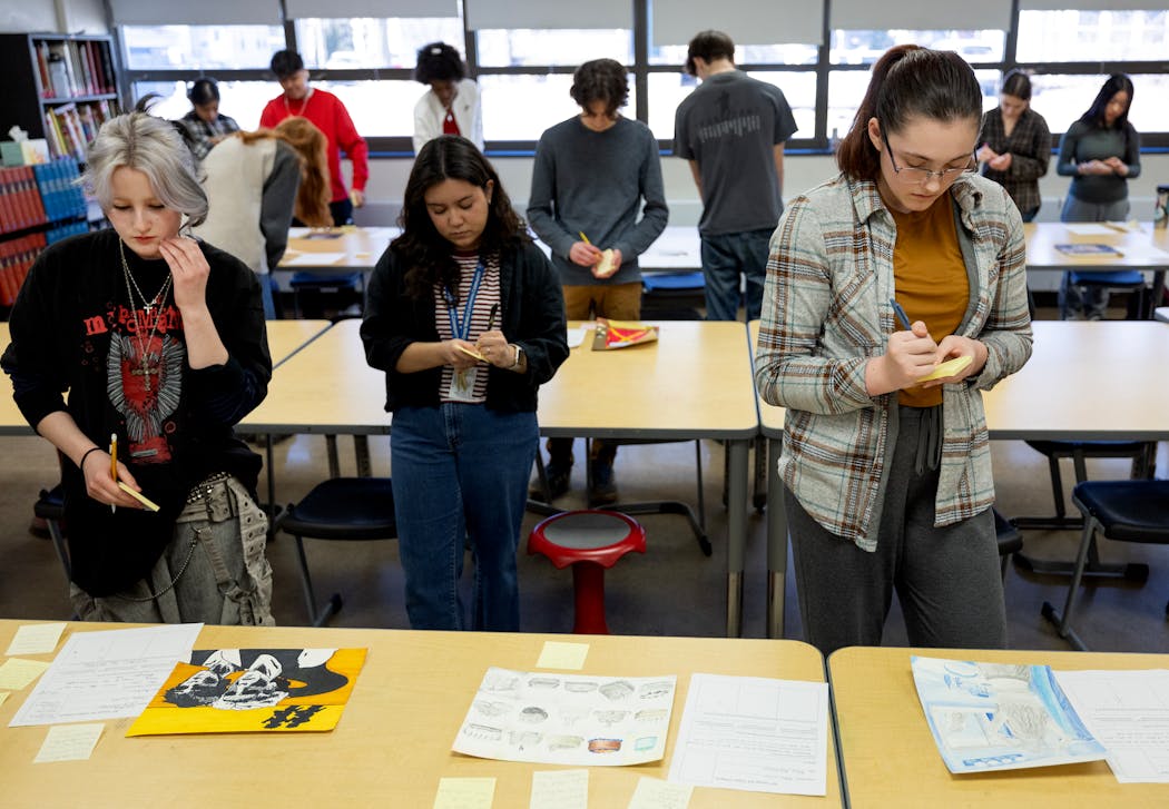 Cal Schmid, 17, left, and Galadrial Barrett, 16, right, write notes for a class critique during an AP art class on Feb. 29 at St. Paul's Open World Learning Community.