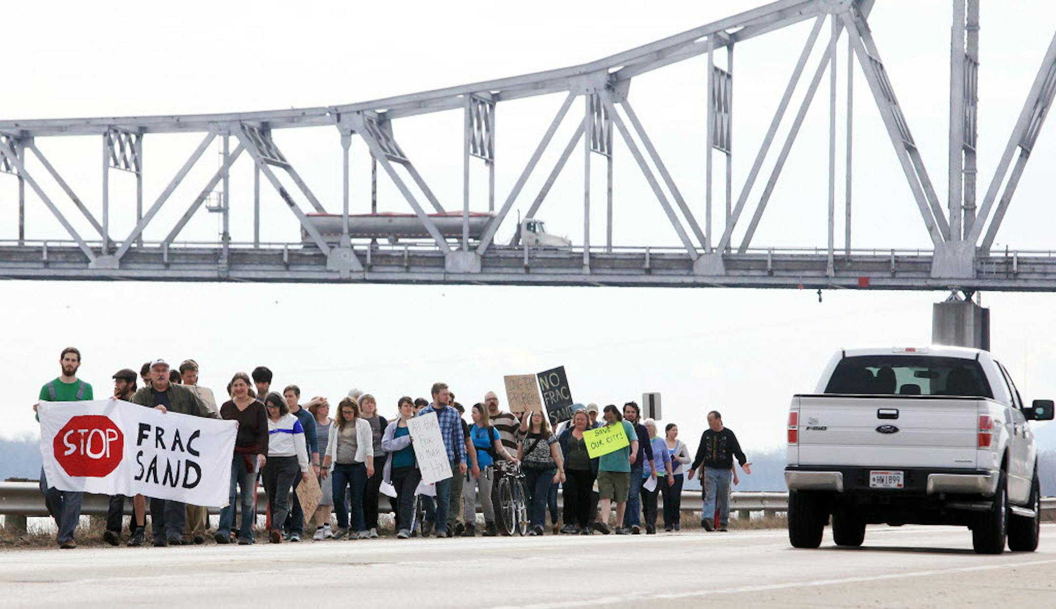 Frac sand protesters walk along Riverview Drive to the commercial dock in Winona on Monday.