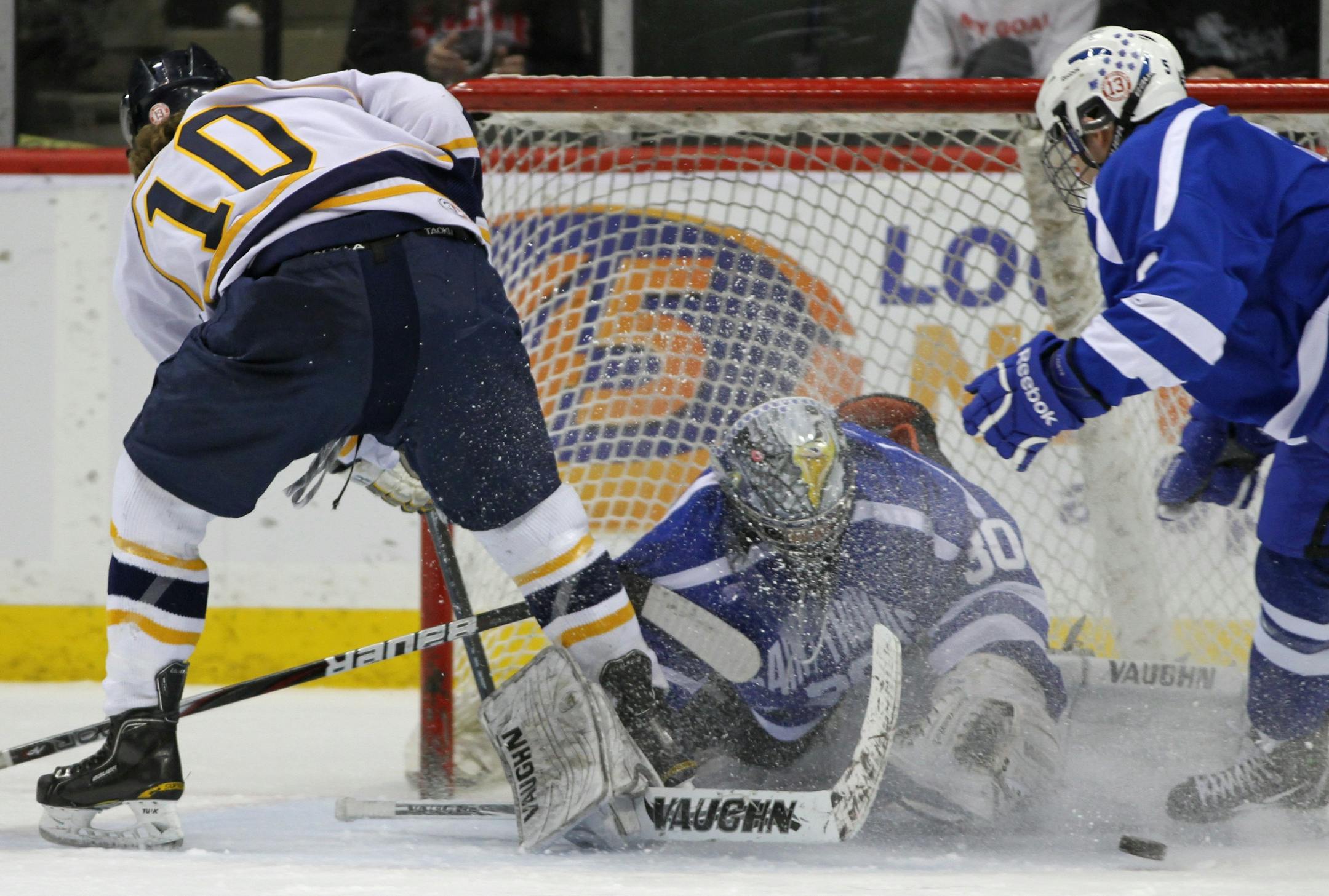 Boys State Hockey Tournament, Class A Championship, St. Thomas Academy vs. Hermantown, 3/10/12. (left to right) Hermantown's Jared Thomas shot on goal was blocked by STA goalie David Zevnik in first period action.