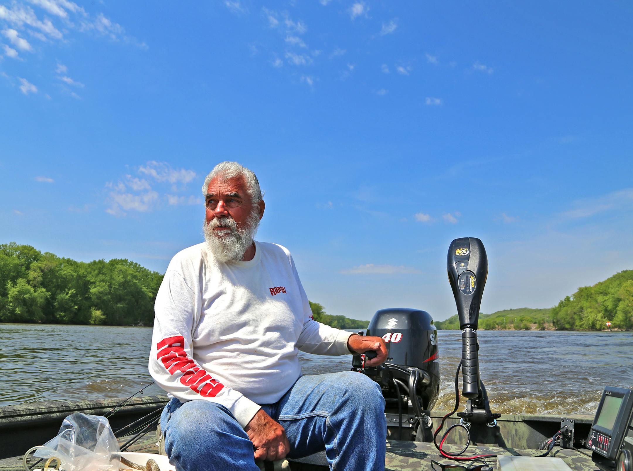 Dick "Griz'' Grzywinski pilots his boat near Red Wing in spring, then, later, on the St. Croix,. following walleyes and sauger. Here he neared the confluence of the St. Croix and Mississippi rivers.