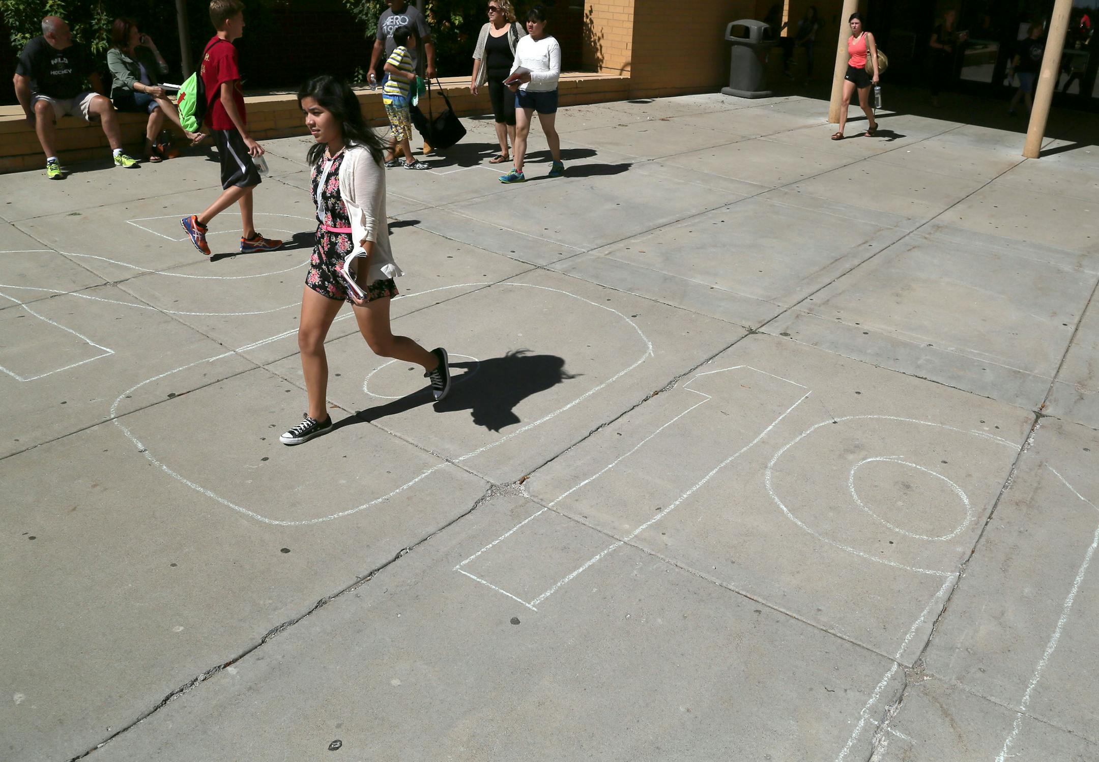 Students come and go past a large sidewalk chalking of the year freshman will graduate following Pepfest for incoming freshmen in the gym at Lakeville South High Thursday, Sept. 20, 2015.](DAVID JOLES/STARTRIBUNE)djoles@startribune.com Pepfest for incoming freshmen in the gym at Lakeville South High.