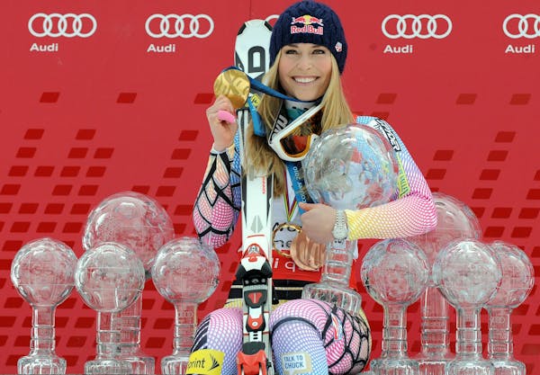 Lindsey Vonn poses in 2010 with Olympic medals and Women's World Cup skiing trophies