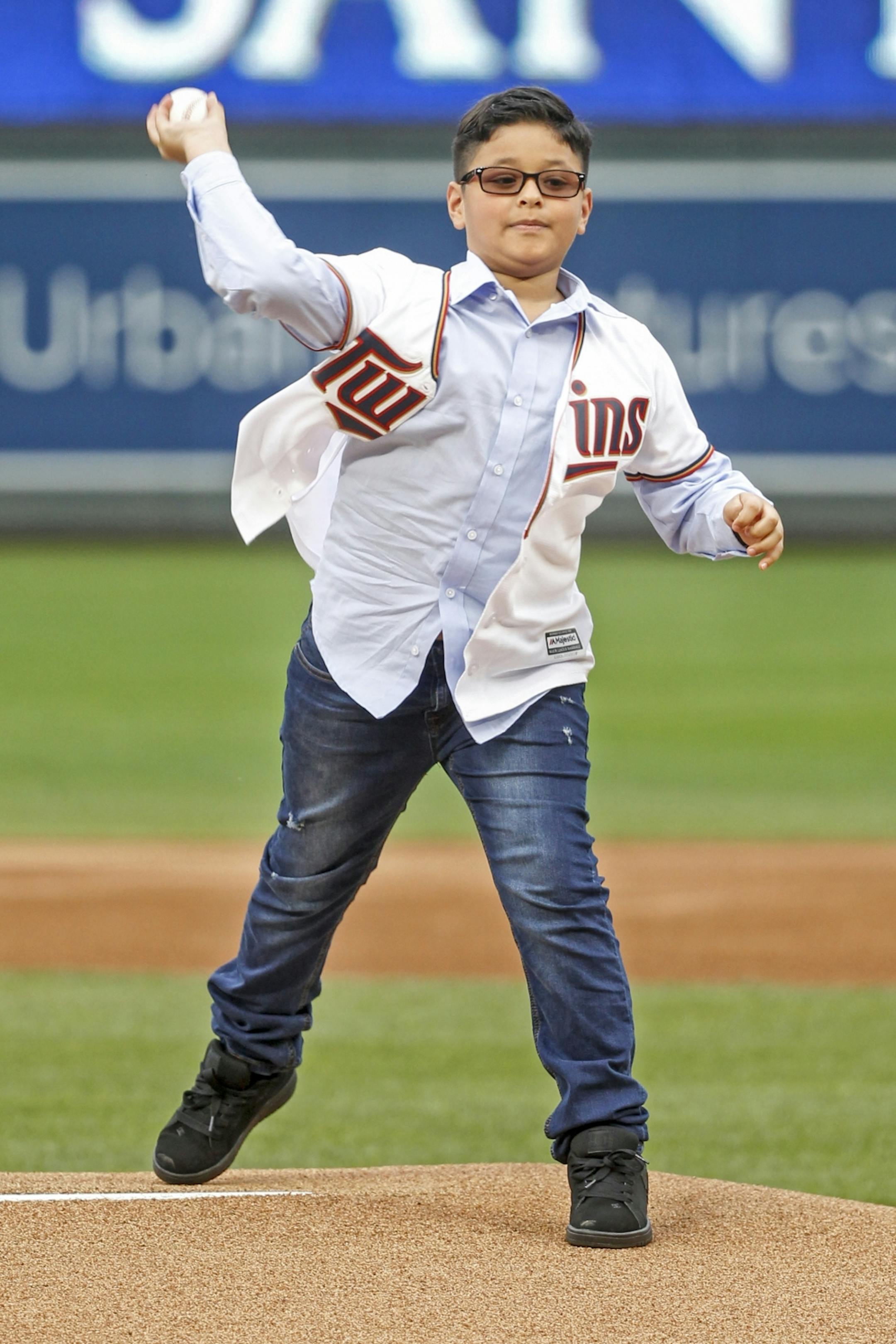 Former Minnesota Twins pitcher Johan Santana's son, Johan Santana Jr., throws out a ceremonial pitch to his dad, who was inducted into the team's Hall of Fame, before the Twins' baseball game with the Kansas City Royals on Saturday, Aug. 4, 2018, in Minneapolis. The Twins won 8-2.