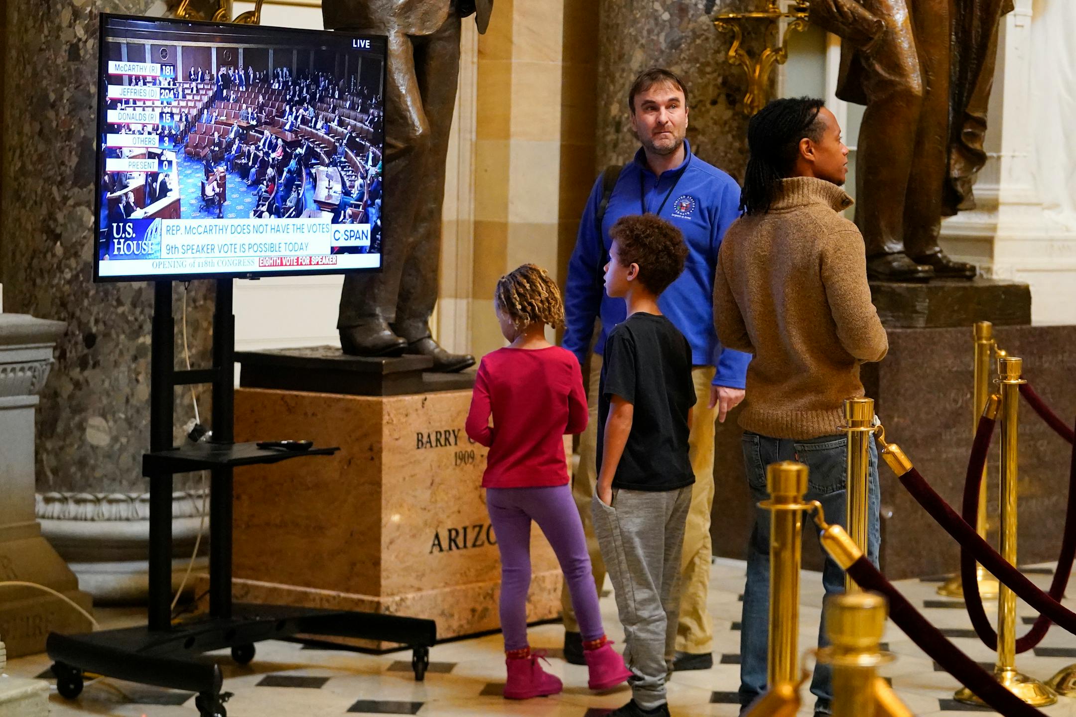 Children look at a monitor in Statuary Hall as the House meets for the third day to elect a speaker and convene the 118th Congress in Washington, Thursday, Jan. 5, 2023. (AP Photo/Julio Cortez)