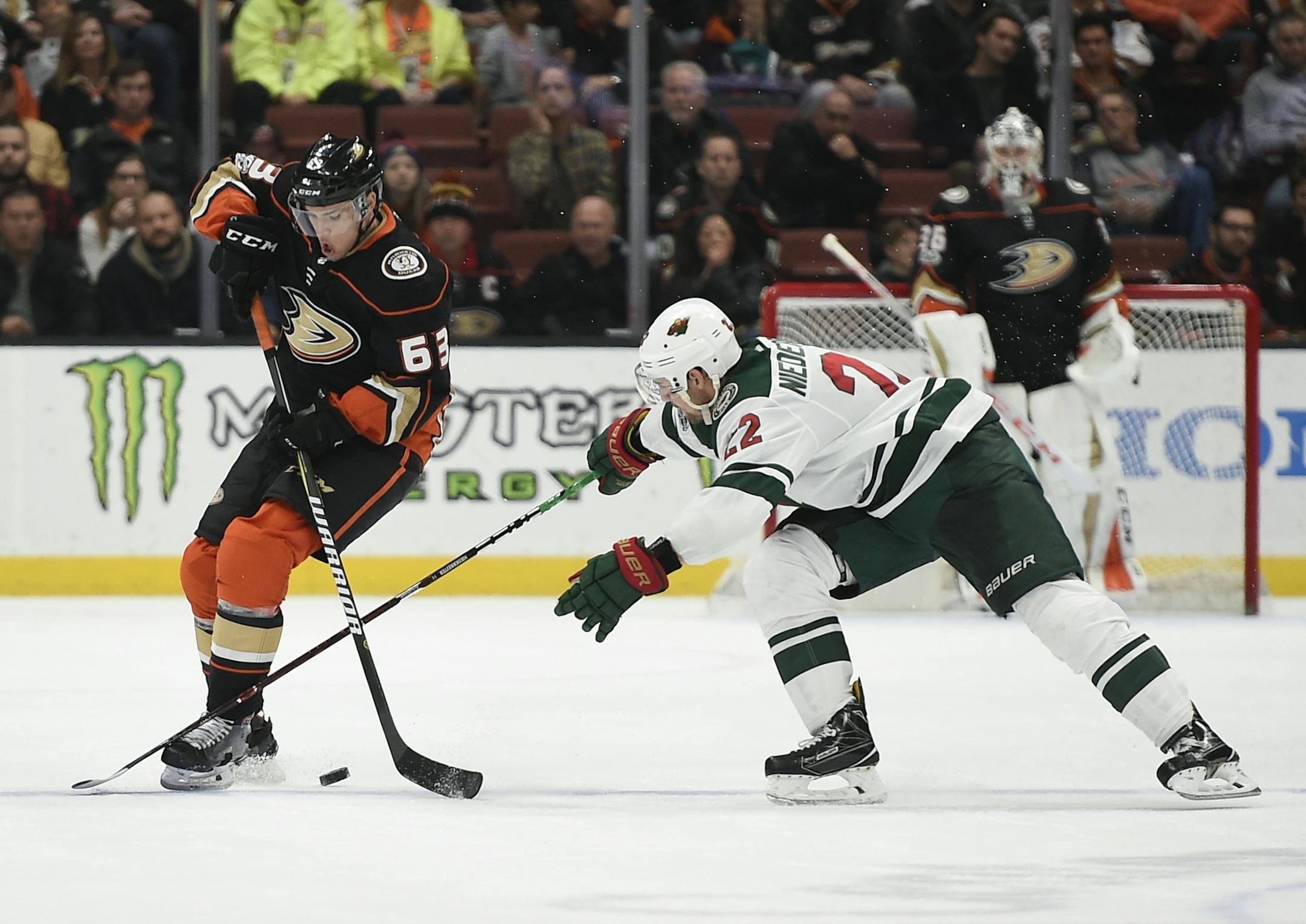 Anaheim Ducks left wing Kevin Roy, left, moves the puck defended by Minnesota Wild right wing Nino Niederreiter during overtime of an NHL hockey game in Anaheim, Calif., Friday, Dec. 8, 2017. The Wild won 3-2 in overtime. (AP Photo/Kelvin Kuo)