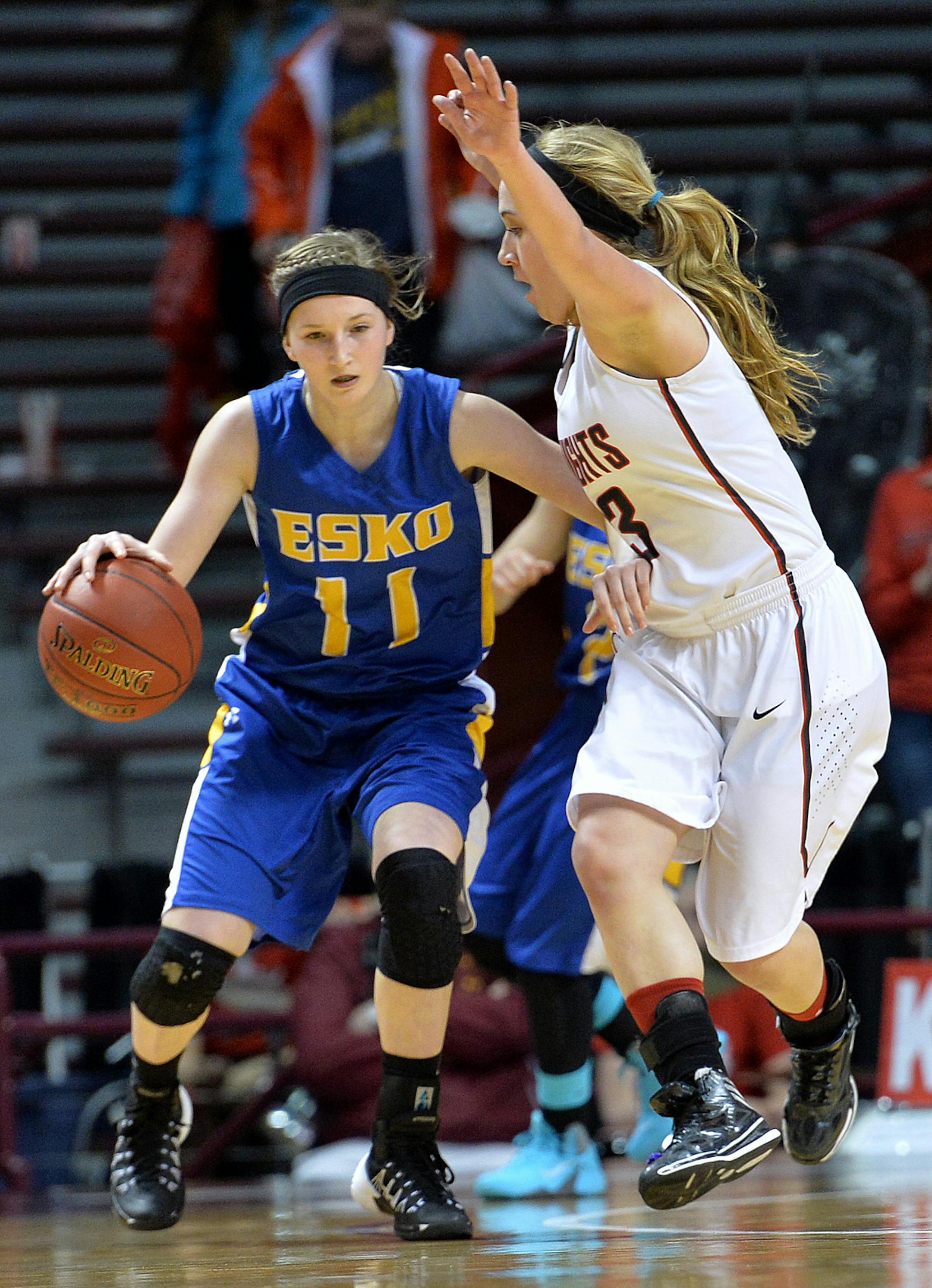 Esko's Judy Wagemaker controls the ball with pressure from Kenyon-Wanamingo's Audra Clark during the first half of a semifinal game of the Class 2A girls' state basketball tournament Friday night at Williams Arena. ] (SPECIAL TO THE STAR TRIBUNE/BRE McGEE) **Judy Wagemaker (blue, 11), Audra Clark (white, 13)