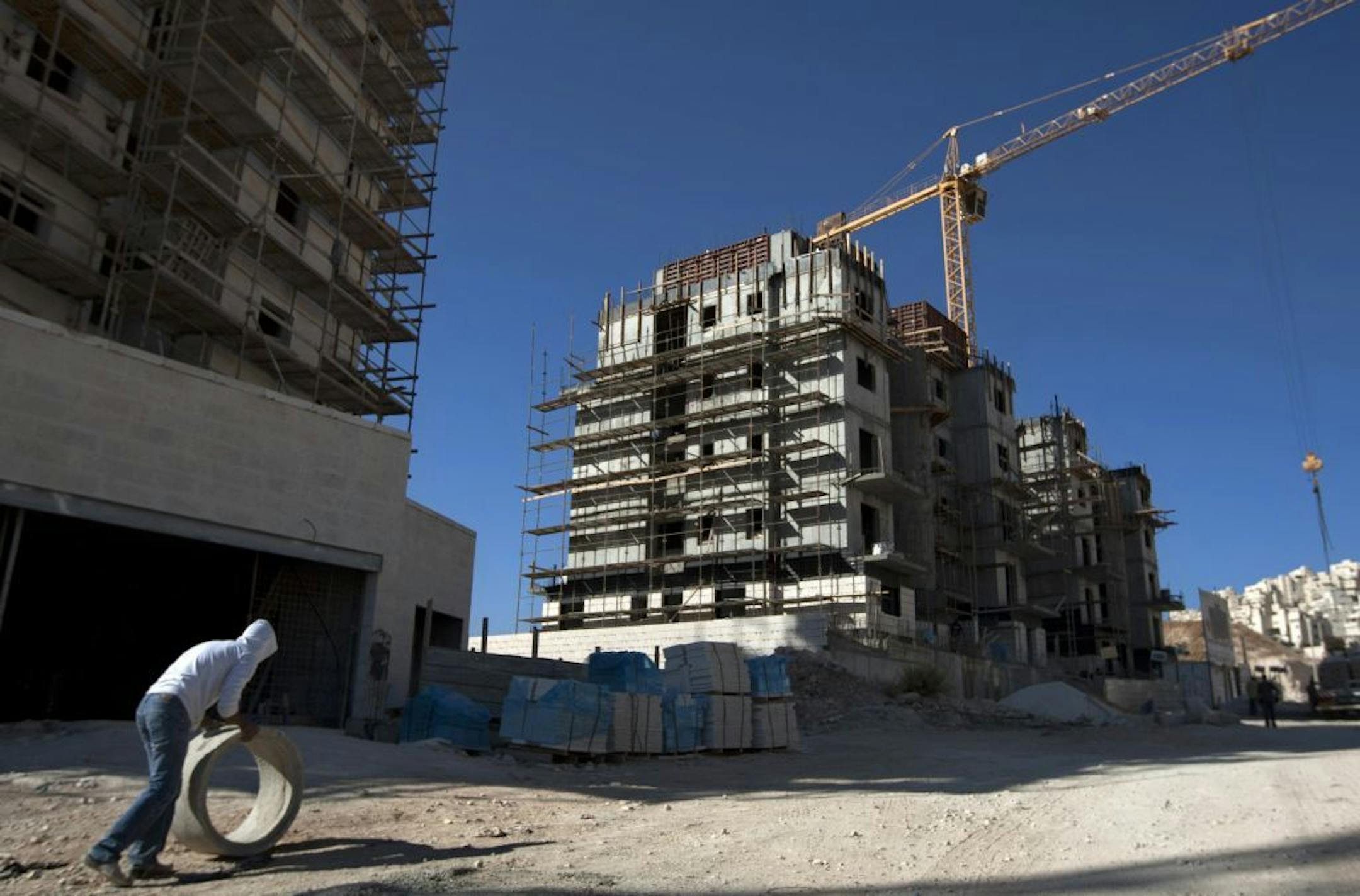 FILE- In this Nov. 2, 2011 file photo, a construction worker works at a site of a new housing unit in the east Jerusalem neighborhood of Har Homa. Israel approved the construction of 3,000 homes in Jewish settlements in the West Bank and east Jerusalem, a government official said Friday, in what appeared to be a defiant response to the Palestinians' successful United Nations recognition bid. The United Nations voted overwhelmingly Thursday to accept "Palestine" in the West Bank, the Gaza Strip a