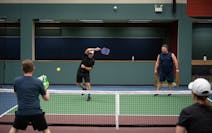 Jerry Baack, CEO of Bridgewater Bank, returned a shot as he and Alex Bisanz played a match against Tony Ferraro, left, and Katie Morrell at the Minnea