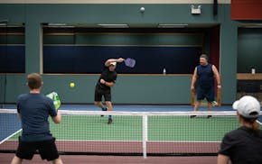 Jerry Baack, CEO of Bridgewater Bank, returned a shot as he and Alex Bisanz played a match against Tony Ferraro, left, and Katie Morrell at the Minnea