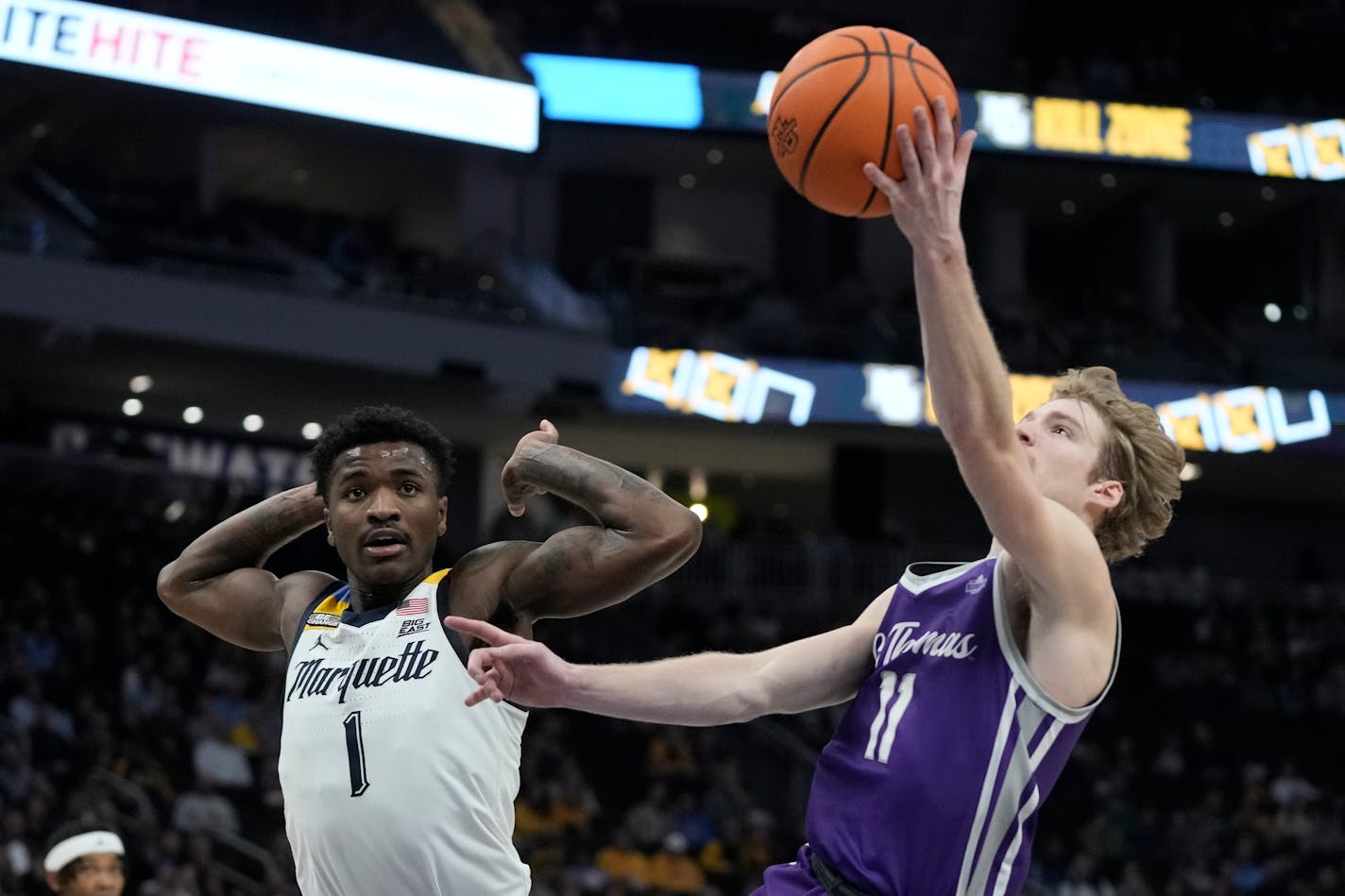 St. Thomas's Drake Dobbs shoots against Marquette's Kam Jones during the second half of an NCAA college basketball game Thursday, Dec. 14, 2023, in Milwaukee. Marquette won 84-79. (AP Photo/Morry Gash)