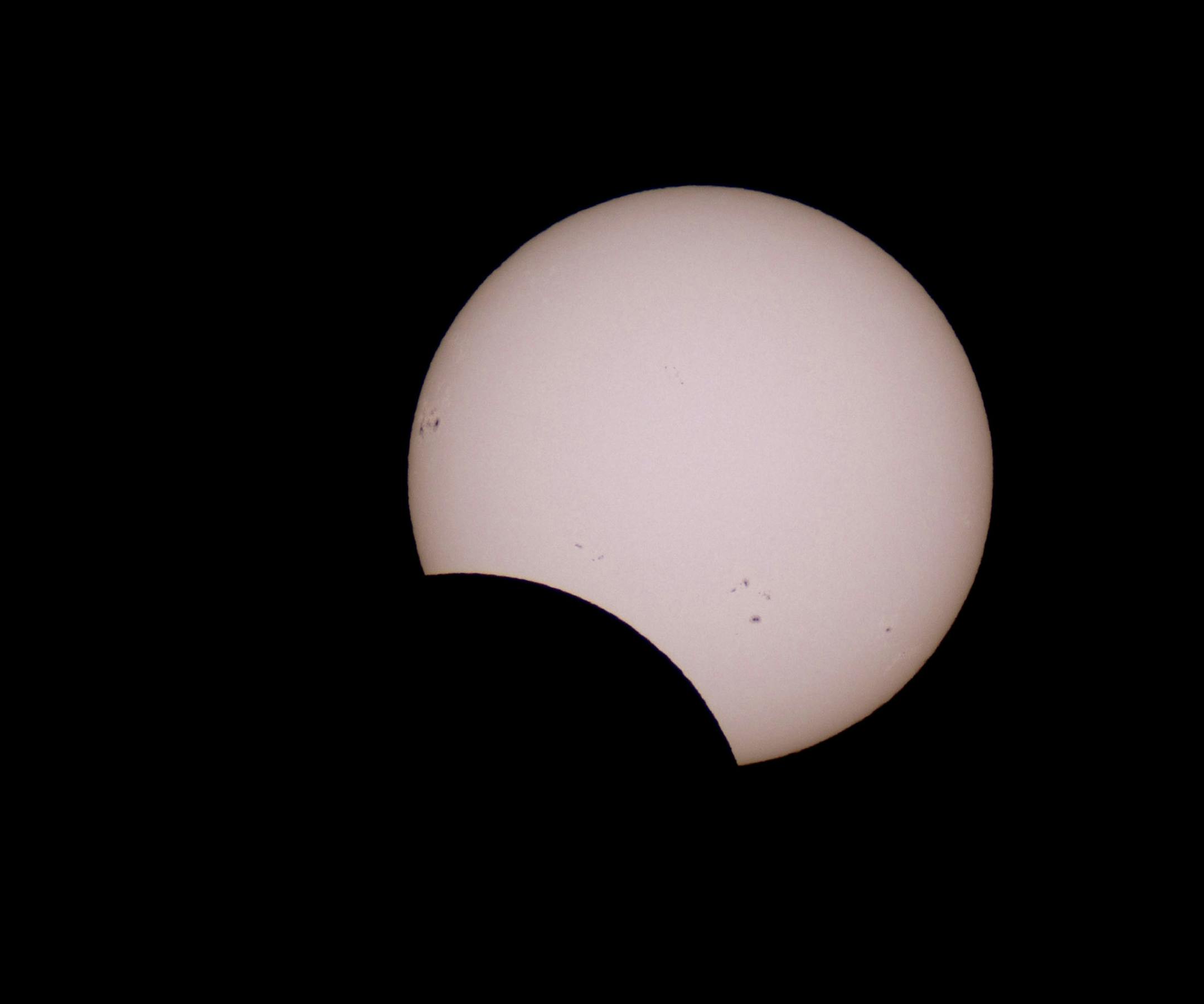 The moon crosses in front of the sun during a partial solar eclipse as seen from the Givatayim Observatory, near Tel Aviv, Israel, Sunday, Nov. 3, 2013. People gathered at the Israeli Astronomical Association center to watch the partial solar eclipse. (AP Photo/Ariel Schalit)
