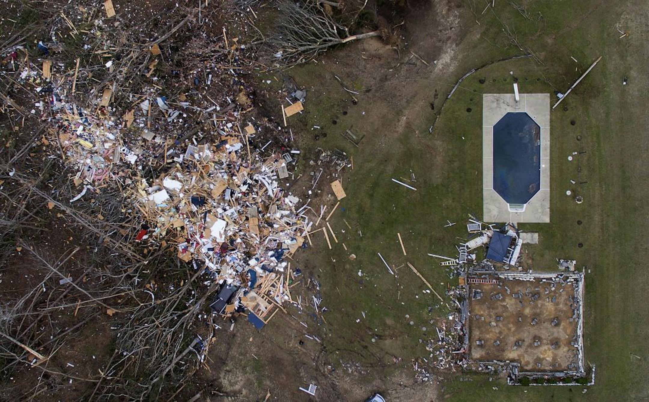 Debris from a home litters a yard the day after a tornado blew it off its foundation, lower right, in Beauregard, Ala., Monday, March 4, 2019.