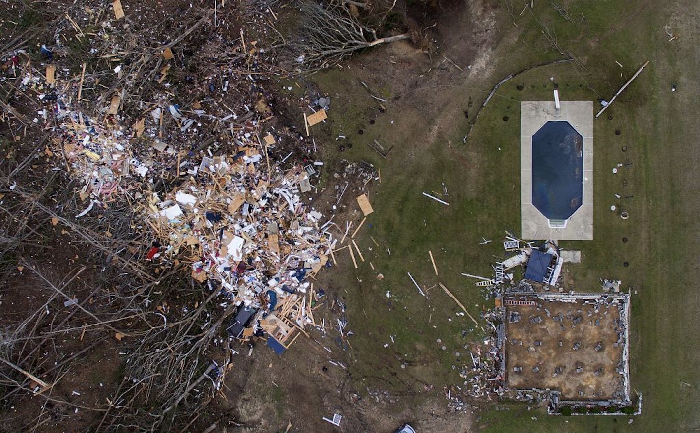 Debris from a home litters a yard the day after a tornado blew it off its foundation, lower right, in Beauregard, Ala., Monday, March 4, 2019.