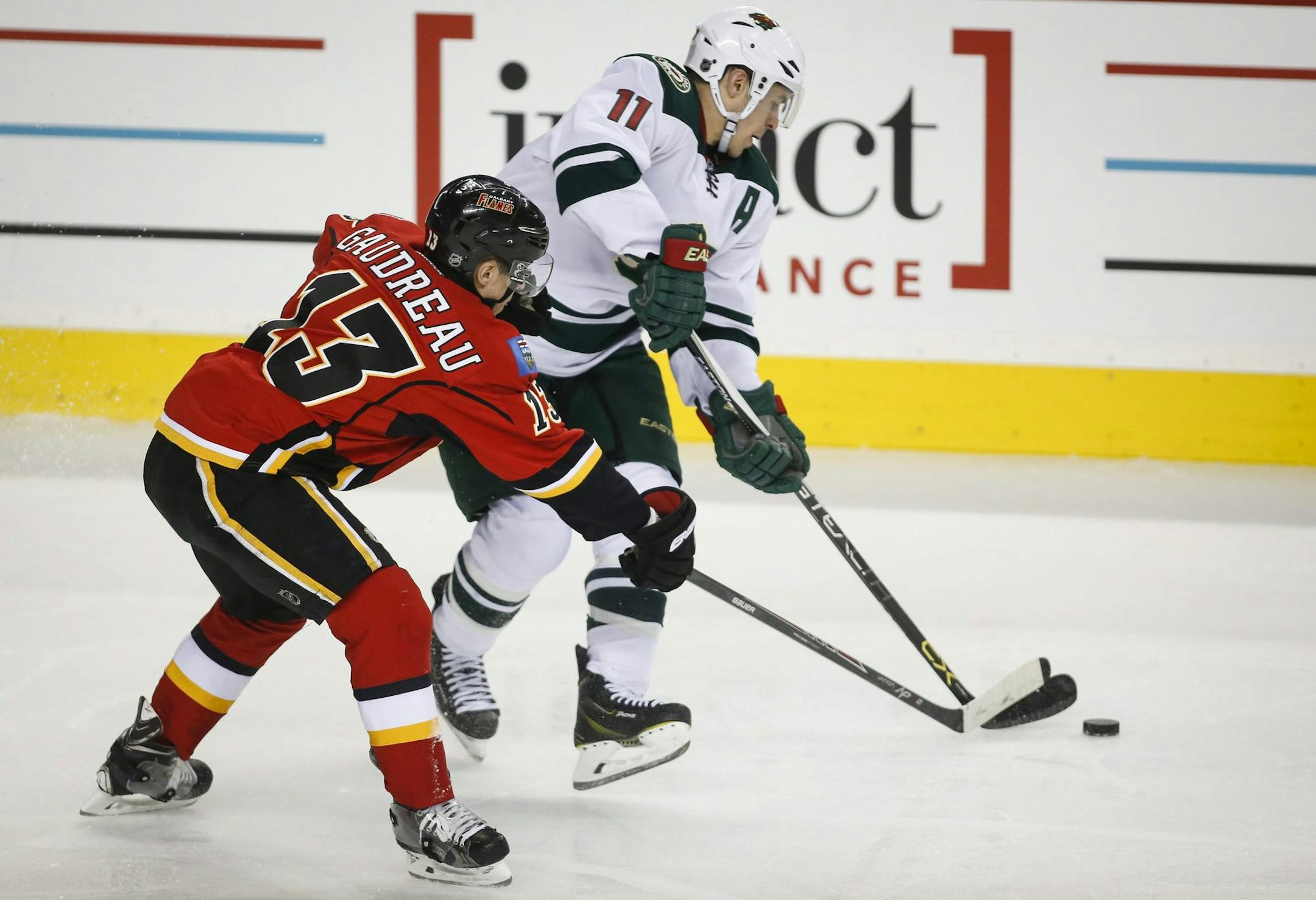 Minnesota Wild Zach Parise, right, gets away from Calgary Flames Johnny Gaudreau during the second period of an NHL hockey game, Wednesday, Feb. 18, 2015 in Calgary, Alberta. (AP Photo/Canadian Press, Jeff McIntosh)