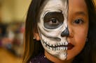 Khloe Flores-Lara, 8, stood for a portrait to show off her elaborate face-painting, done by her aunt, Kimberly Lara, at Saturday's Dia de los Muertos 