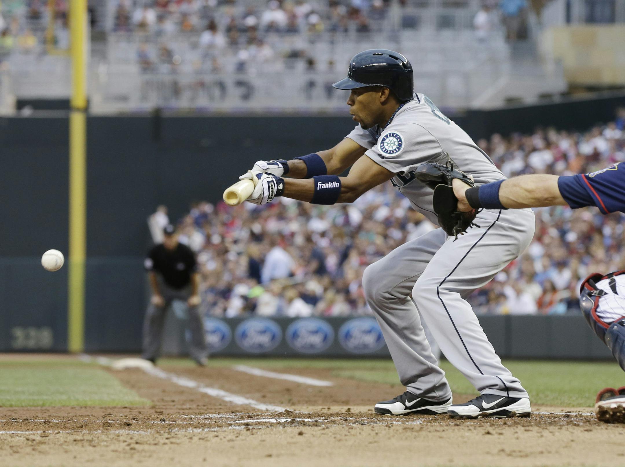 Seattle Mariners' Endy Chavez hits a sacrifice bunt against Minnesota Twins pitcher Mike Pelfrey in the third inning of a baseball game, Friday, May 31, 2013, in Minneapolis. (AP Photo/Jim Mone)