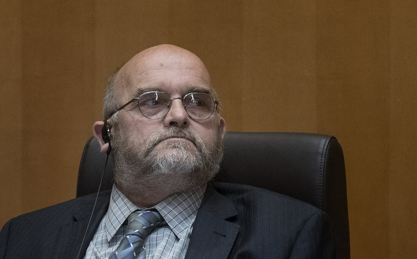 Shakopee city councilman Mike Luce listens to fellow council member Jay Whiting, who demanded that Luce resign, during Tuesday's council meeting.