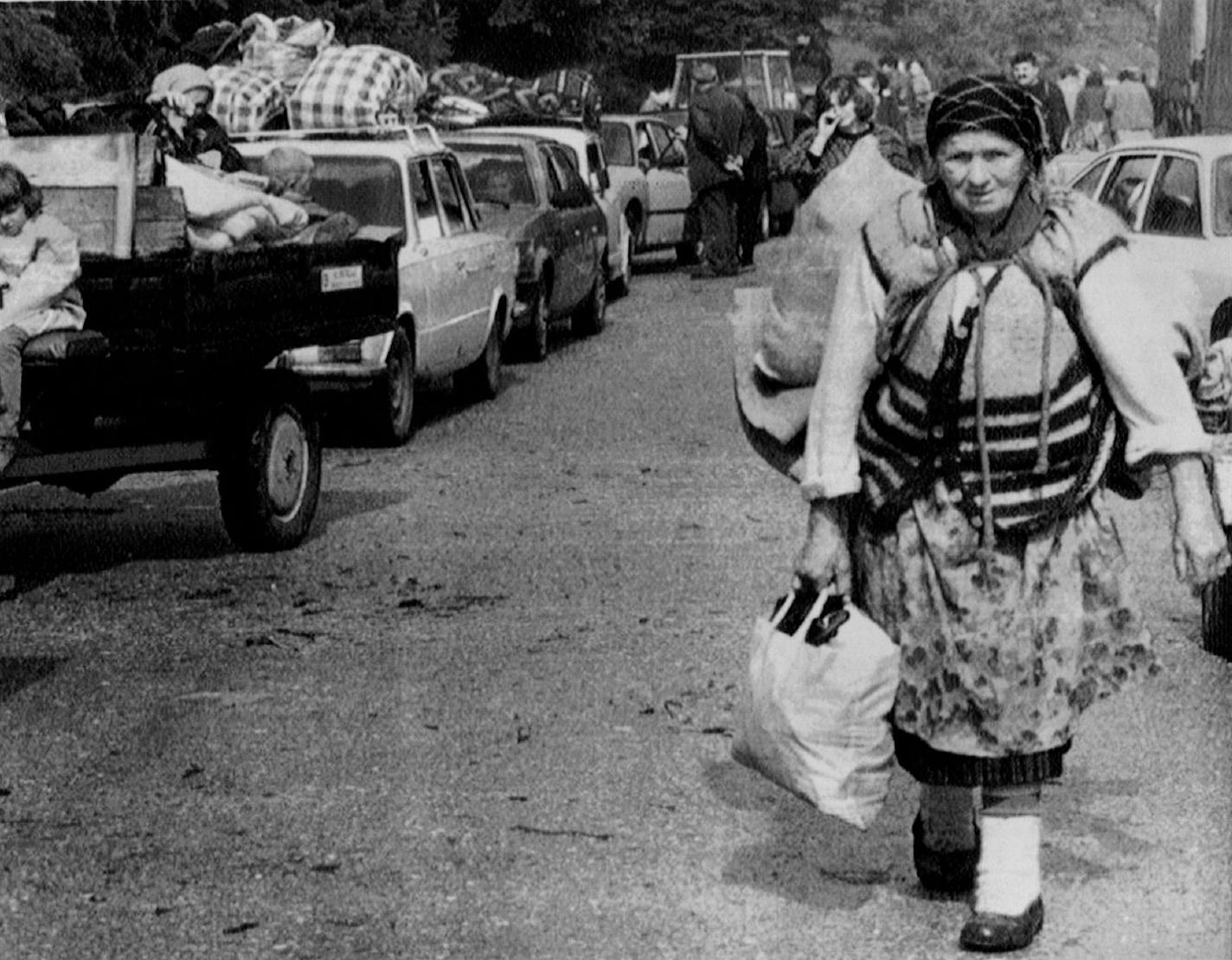 June 9, 1993 A Bosnian Crost woman walks past a line of vehicles near Mount Vlasic, Tuesday, Muslim troops swept away outmanned Bosnian Crost forces and drove thousands of civilians and soldiers into the arms of Serbs encamped on Mount Vlasic, north of Travnik. Radivoje Pavicic, AP Photo