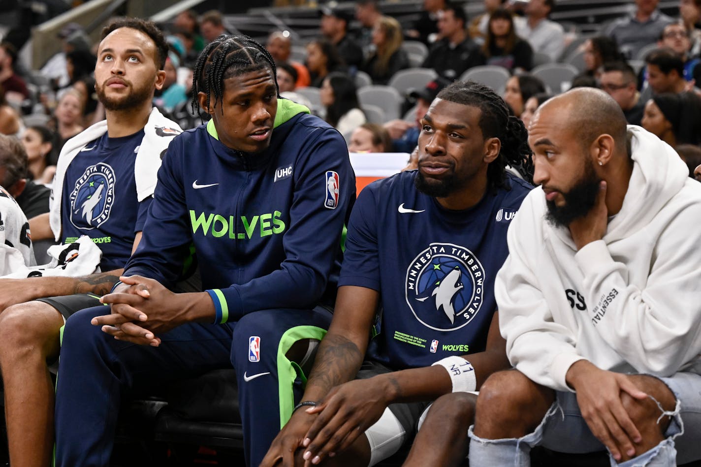 Minnesota Timberwolves players Kyle Anderson (from left), Nathan Knight, Naz Reid, and Jordan McLaughlin sit on the bench during the first half of an NBA basketball game against the San Antonio Spurs, Sunday, Oct. 30, 2022, in San Antonio. San Antonio won 107-98. (AP Photo/Darren Abate)