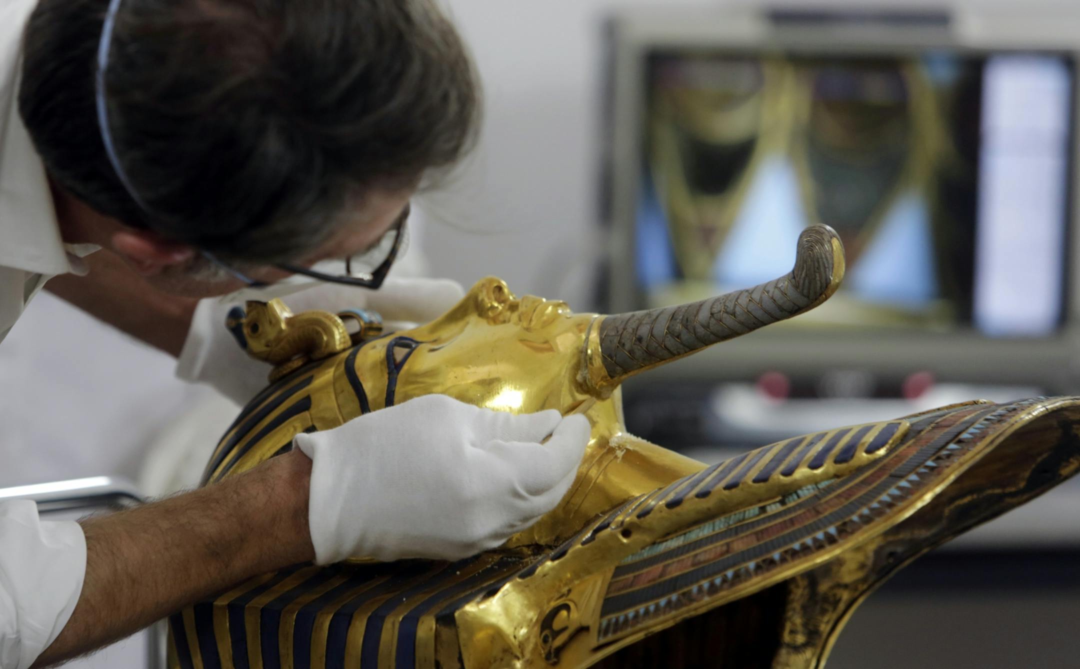 German restorer Christian Eckmann begins restoration work on the golden mask of King Tutankhamun over a year after the beard was accidentally broken off and hastily glued back with epoxy, at the Egyptian Museum in Cairo, Egypt, Tuesday, Oct. 20, 2015. The 3,300-year-old burial pharaonic mask was discovered in Tutankhamun's tomb along with other artifacts by British archeologists in 1922, sparking worldwide interest in archaeology and ancient Egypt.