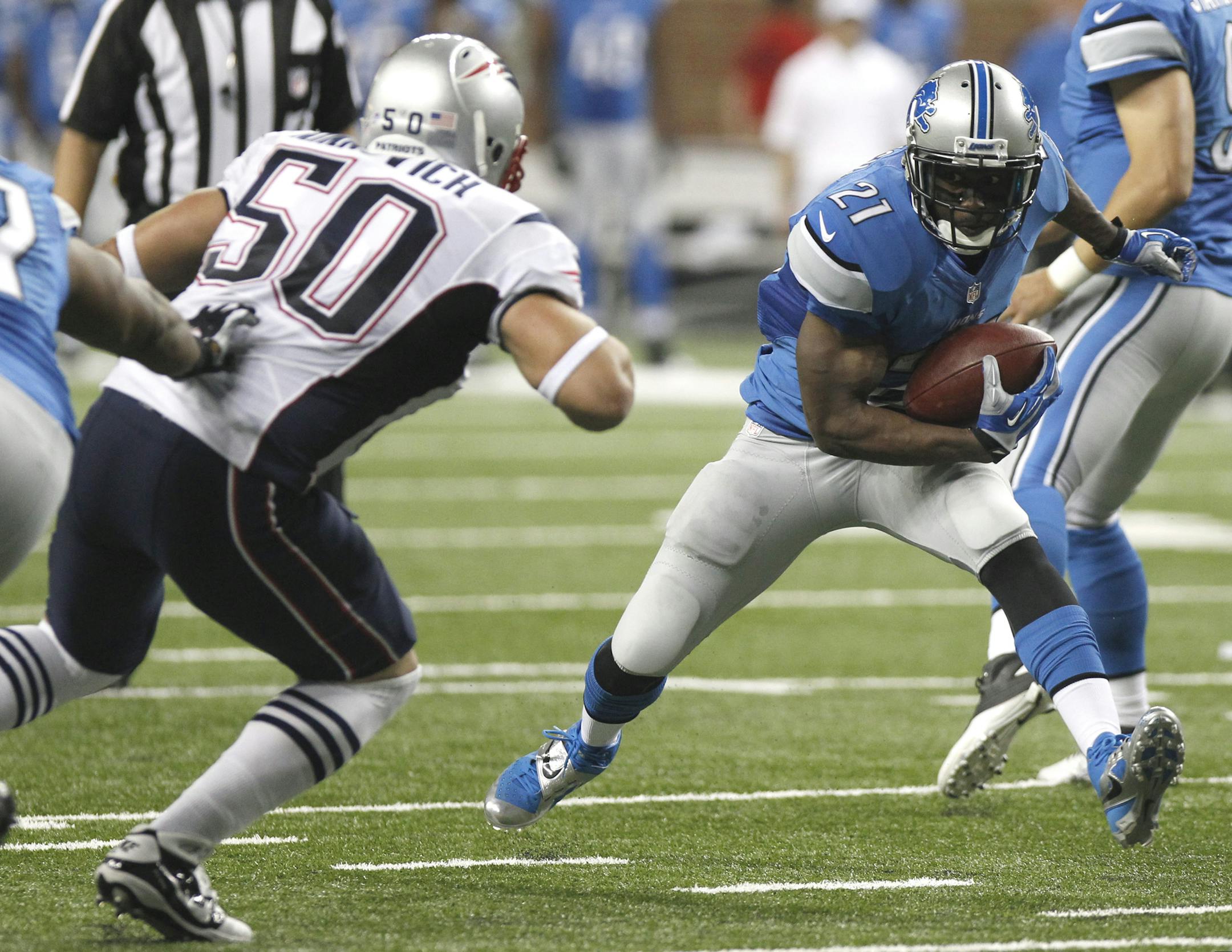 Detroit Lions running back Reggie Bush (21) carries against New England Patriots defensive end Rob Ninkovich (50) in the second quarter of an NFL preseason football game in Detroit, Thursday, Aug. 22, 2013. (AP Photo/Duane Burleson)