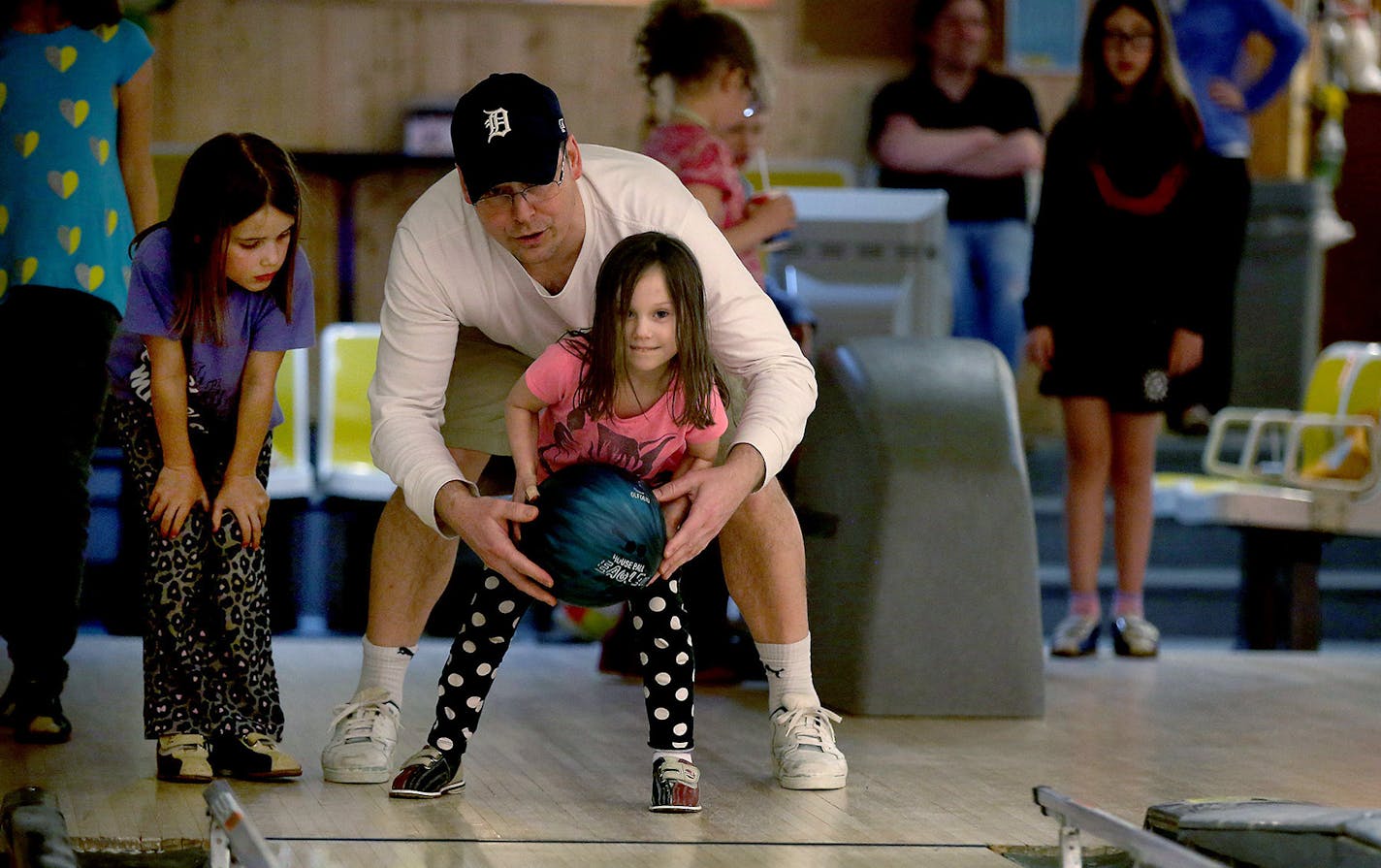 Jeff Sjosten, helped his daughter Emme Sjosten, 6, center, and niece Kennedy Jaeger, 8, left, during a night of bowling at Lariat Lanes, Wednesday, April 1, 2015 in Richfield, MN. Lariat Lanes, a neighborhood staple in Richfield for more than a half-century, is closing next month. ] (ELIZABETH FLORES/STAR TRIBUNE) ELIZABETH FLORES &#x2022; eflores@startribune.com