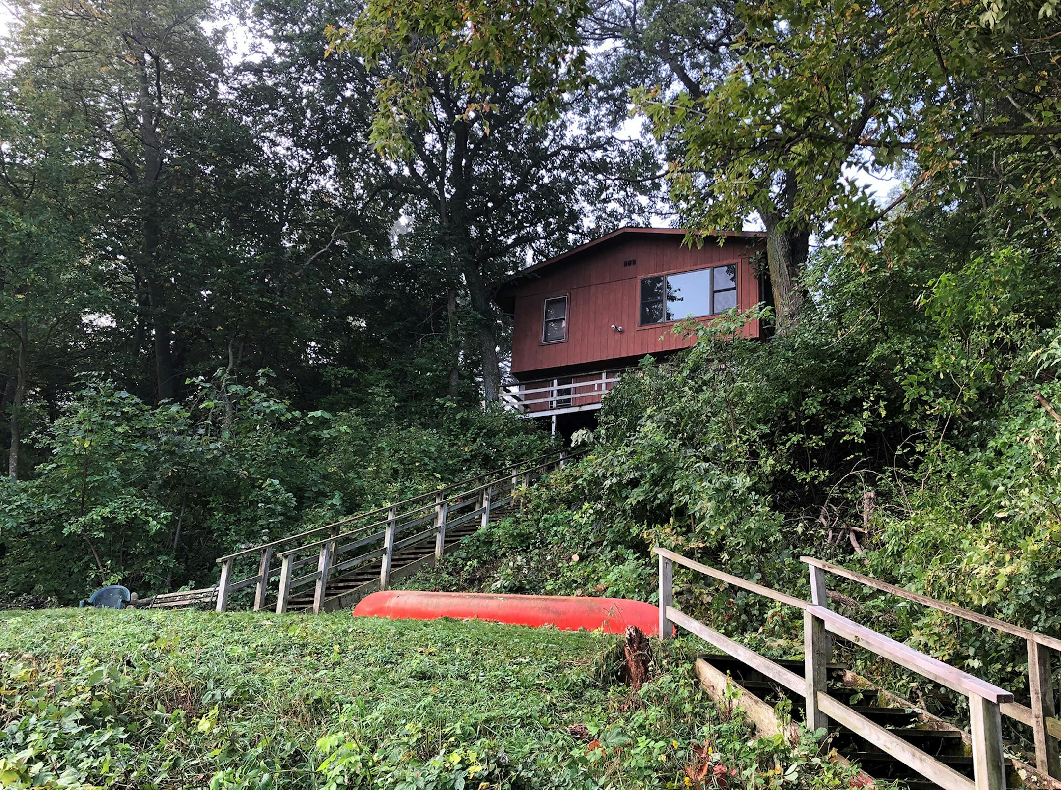 The cabin sits on a steep bank overlooking Lake Minnewaska.