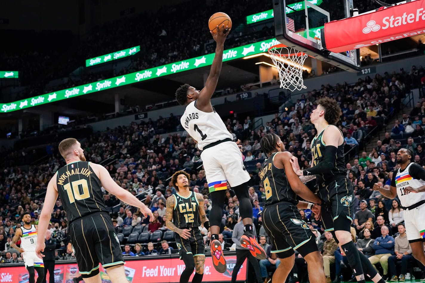 Minnesota Timberwolves guard Anthony Edwards (1) goes up for a shot as Charlotte Hornets forward Svi Mykhailiuk (10), guard Kelly Oubre Jr. (12), guard Dennis Smith Jr. (8) and guard LaMelo Ball watch during the first half of an NBA basketball game Friday, Feb. 24, 2023, in Minneapolis. (AP Photo/Craig Lassig)