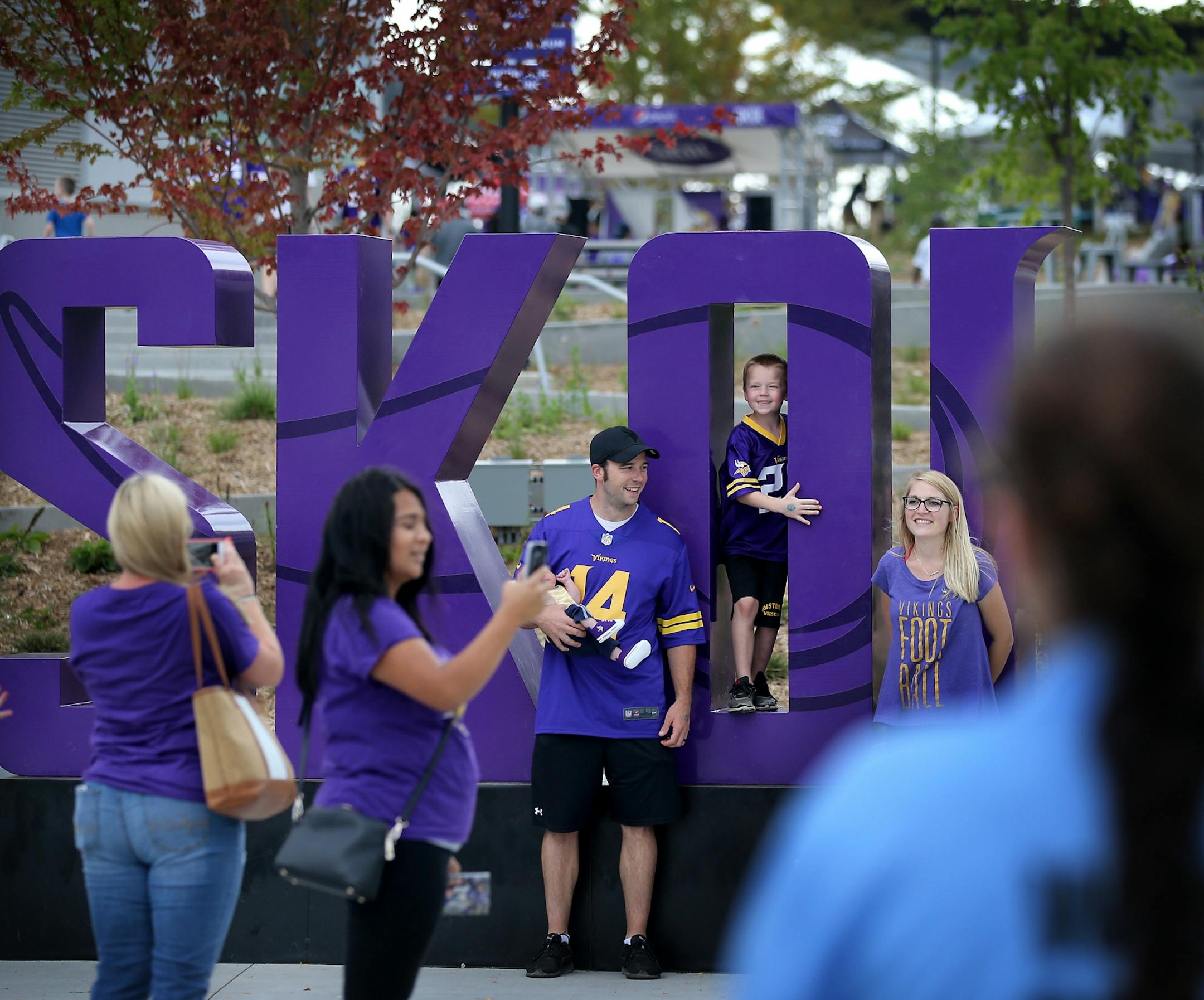 Minnesota Vikings fans pose for photos by a large Skol sign before the start of a Vikings and Jacksonville Jaguars joint practice session Thursday, Aug. 16, 2018, at the TCO Performance Center in Eagan, MN.