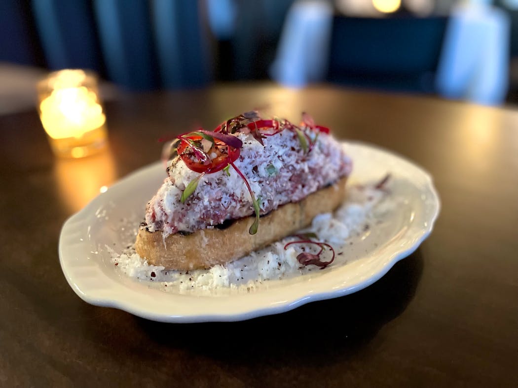 Steak tartare is a heaping mound of meat dressed in marrow aioli with shaved Parmesan cheese and chiles.