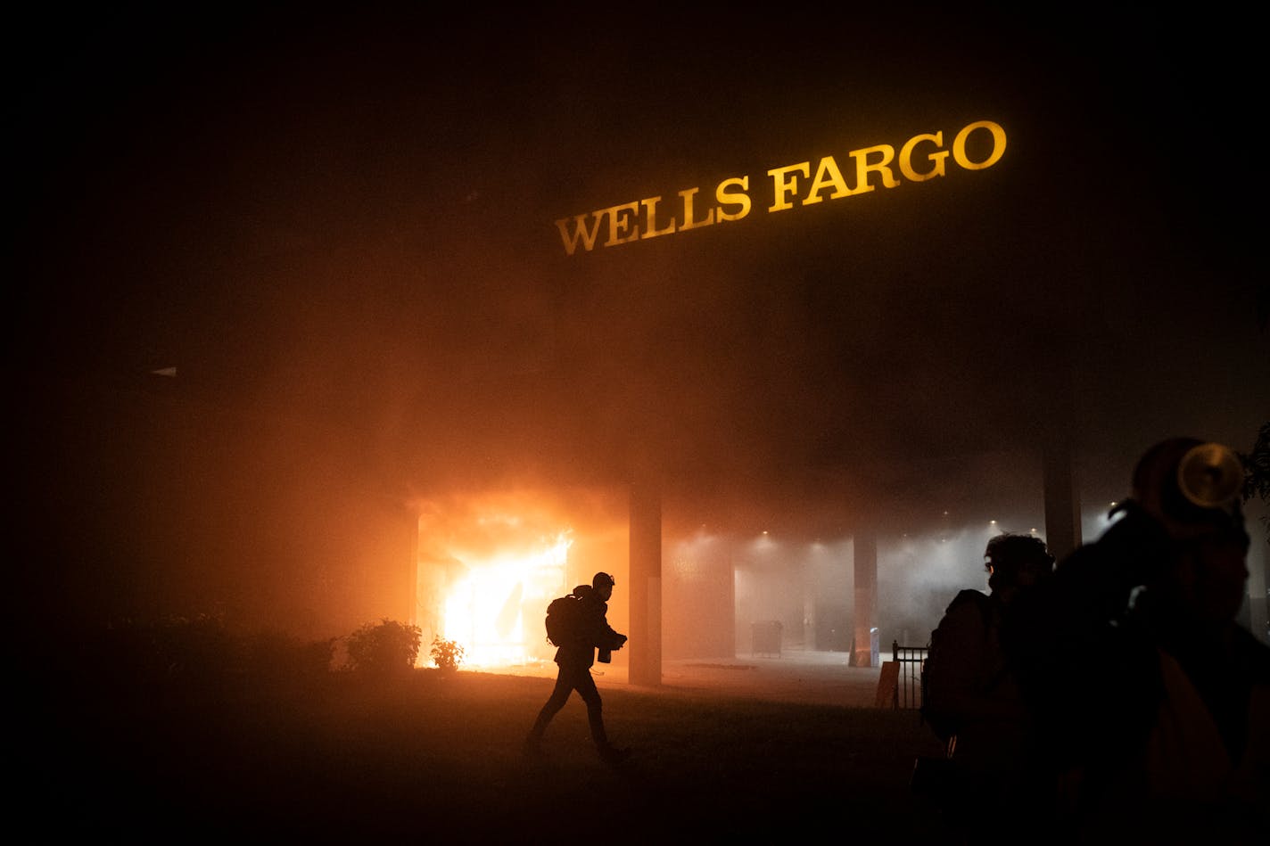 Smoke billowed from a fire at the Wells Fargo near the Fifth Precinct station in Minneapolis on Friday night.