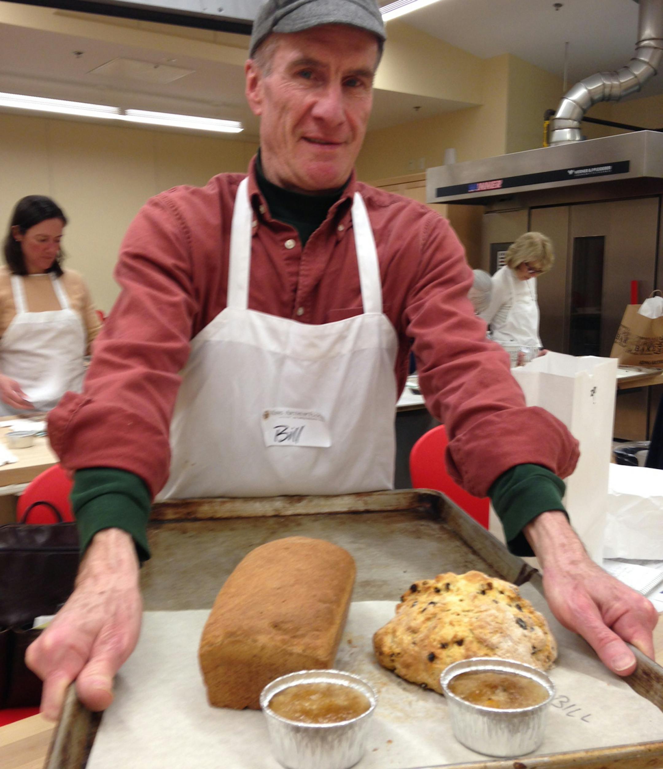 "The author with the results of a three-hour class at the King Arthur Flour Baking Education Center, the night before St. Patrick's Day. Clockwise from upper left: brown bread, traditional Irish bannock, oatmeal brulee. Provided by Bill McAuliffe