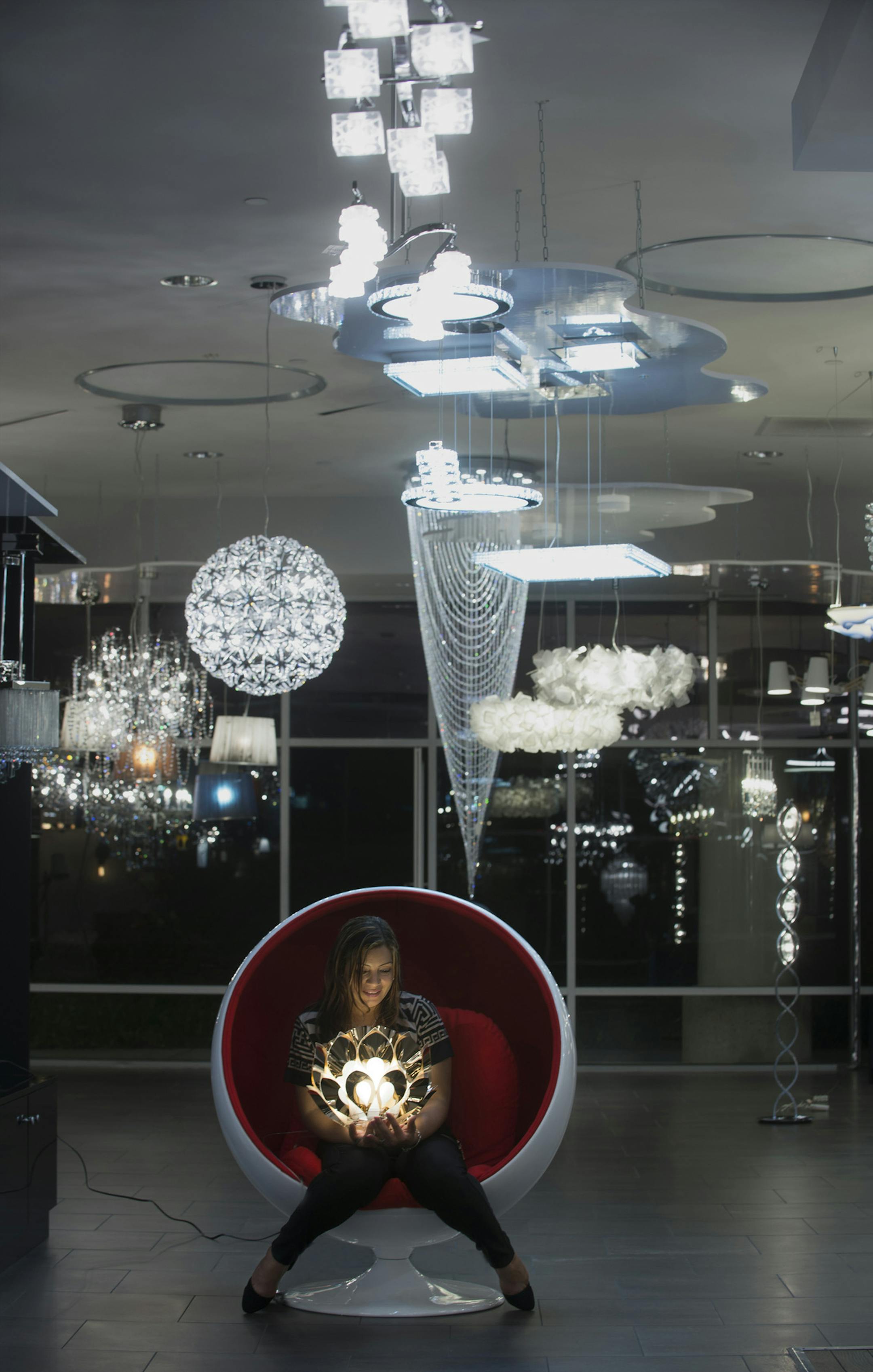 Owner Sandra Lopez is illuminated by a Flora Gold, Silver and Copper light at Euro Moda Lighting and Furniture. She runs the high-end lighting and furniture store in Irvine with her husband, father-in-law and family. (Cindy Yamanaka/Orange County Register/TNS) ORG XMIT: 1181819