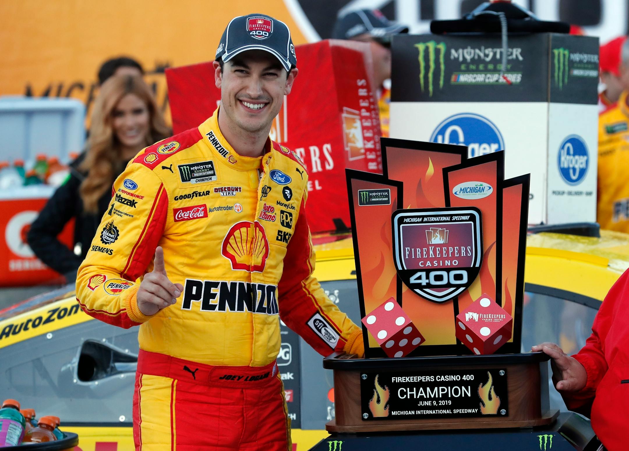 Joey Logano stood with the trophy after winning a NASCAR Cup Series race at Michigan International Speedway on Monday.