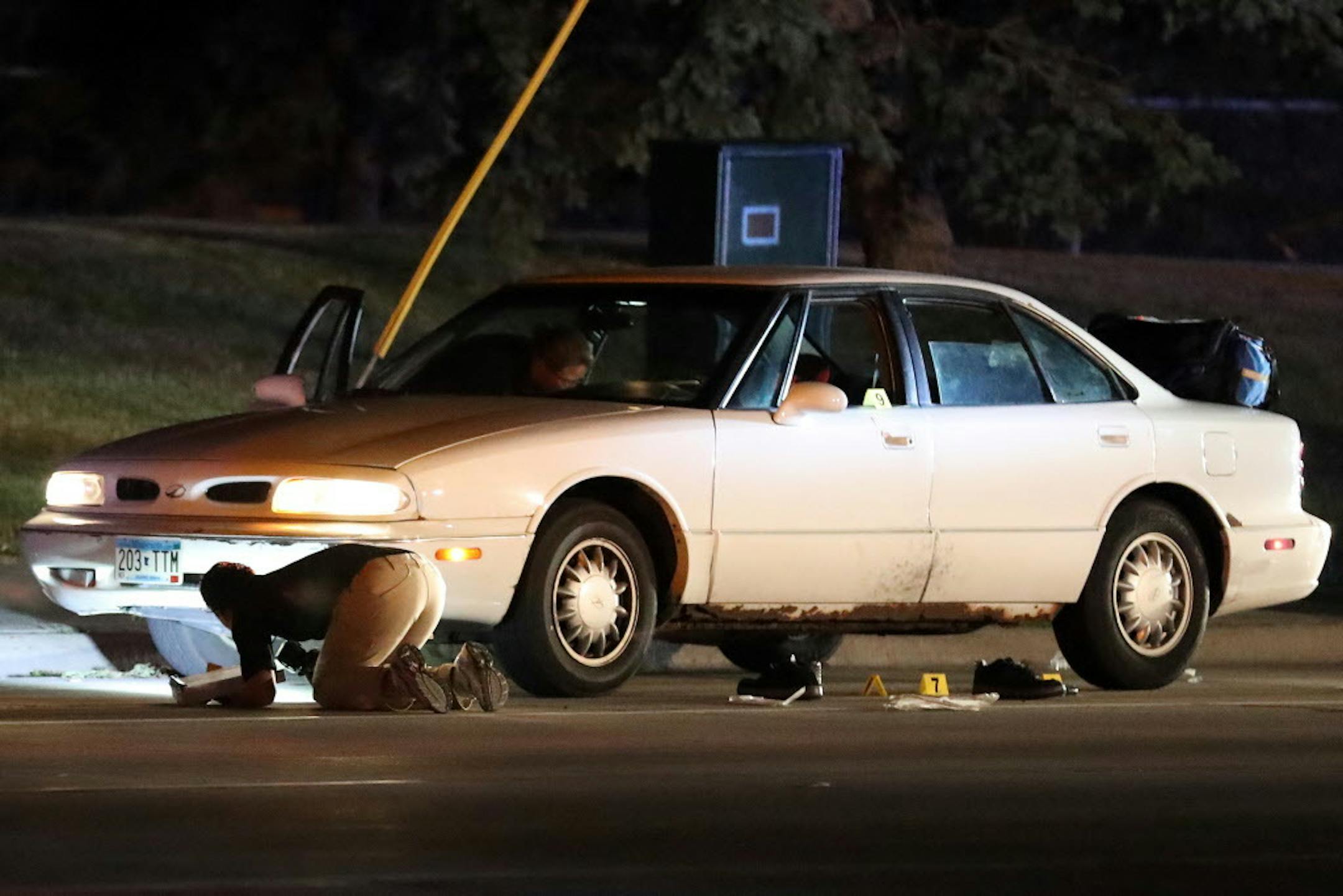 Investigators search a car at the scene of a fatal shooting by a police officer in Falcon Heights on Wednesday, July 6, 2016.