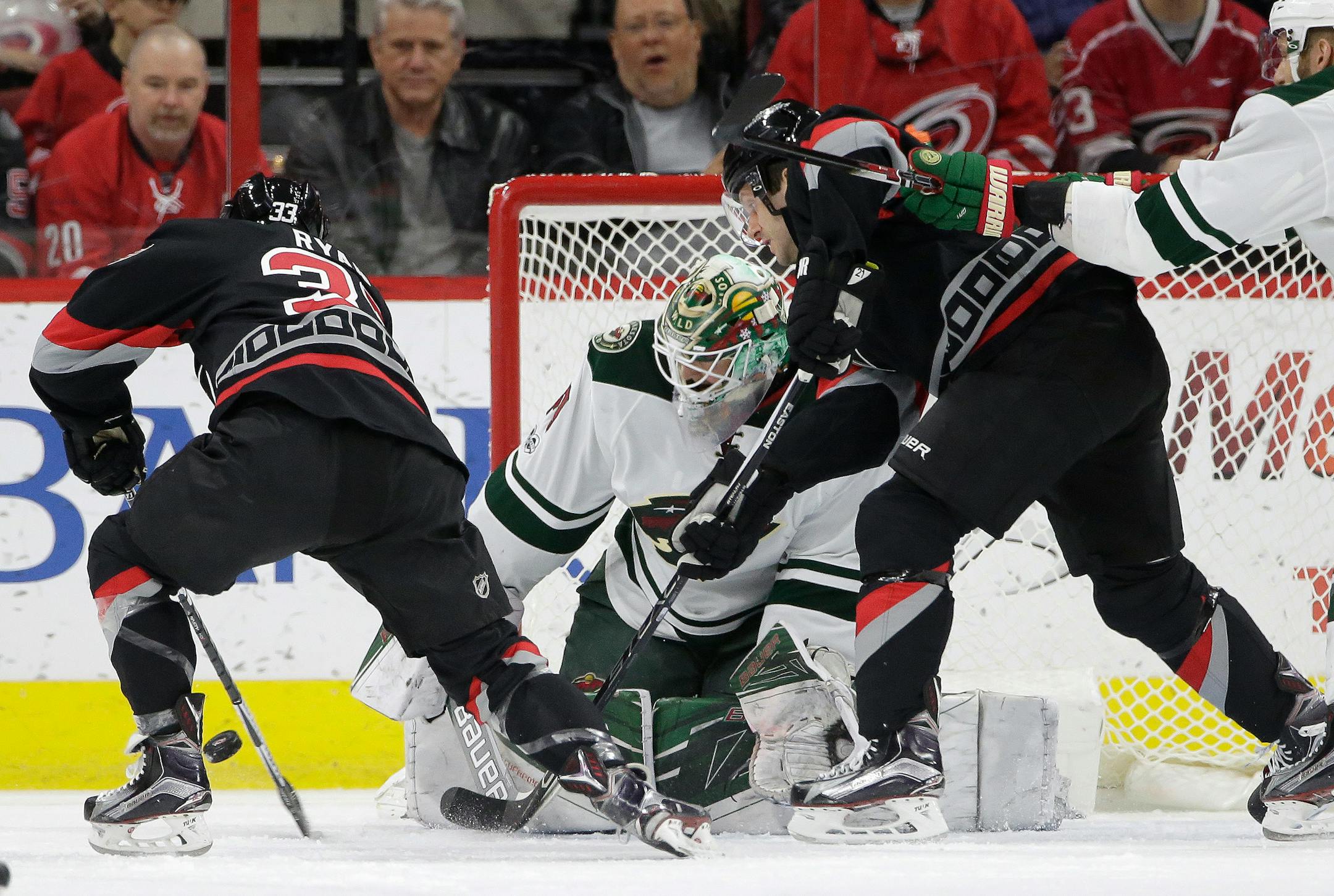 Carolina Hurricanes' Derek Ryan (33) and Lee Stempniak, right, try to score against Minnesota Wild goalie Devan Dubnyk during the first period of an NHL hockey game in Raleigh, N.C., Thursday, March 16, 2017. Ryan scored on the play. (AP Photo/Gerry Broome)
