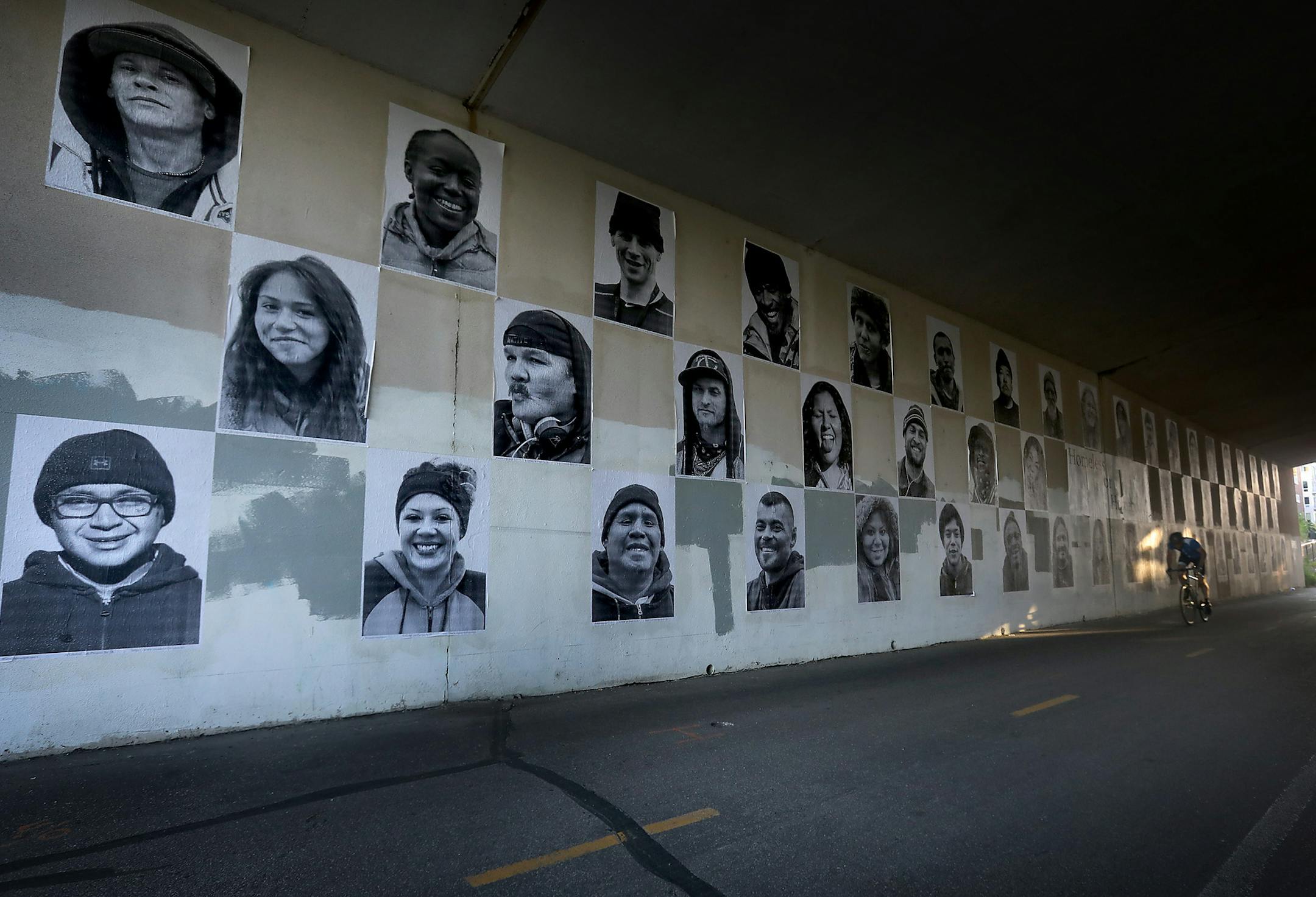 Fifty four portraits of Twin Cities residents, many of whom were residents of the Hiawatha homeless encampment at the time the photos were taken in 2018, are displayed on a wall on the greenway, beneath the Hennepin Ave. bridge and seen Tuesday, June 25. 2019, Minneapolis, MN. Titled: "Homeless or Homebody?" the premise of the photo exhibit is to illicit the viewer to ask, when placed side by side, whether it is possible to tell the difference between those who have a home and those who are home