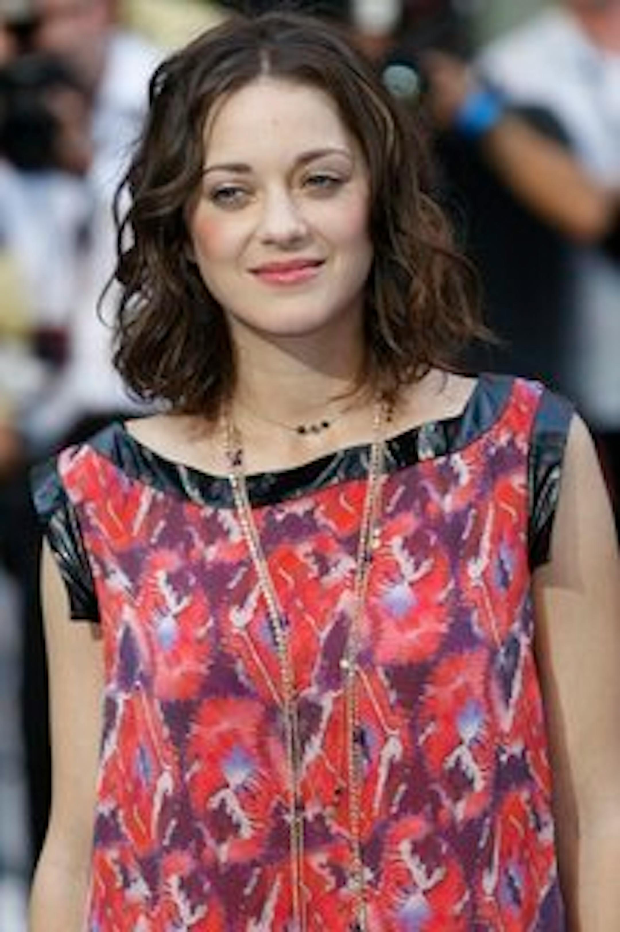 In this July 8, 2010 photo, cast member French actress Marion Cotillard arrives for the world premiere of the film "Inception" in London. A New York City woman faces charges that she sent threatening email messages and videos to a Web site dedicated to Cotillard. FBI agents say in a court filing that Teresa Yuan, of Queens, sent a series of spooky messages in July that included ramblings about wanting to play Russian Roulette with the actress. (AP Photo/Sang Tan)
