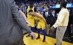 Golden State Warriors' Stephen Curry (30) limps back to the court after injuring his right ankle as teammate Draymond Green (23) checks on his conditi