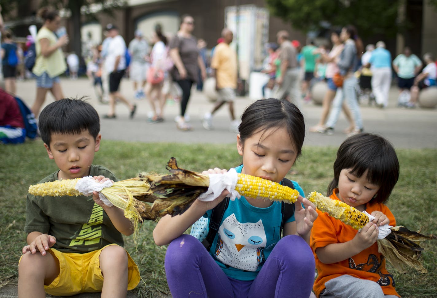 Kylie Yu, 9, center, chowed down on sweet corn from the Roast Corn stand with her brothers, Michael, 5, left, and Charlie, 3, on Thursday at the Minnesota State Fair.