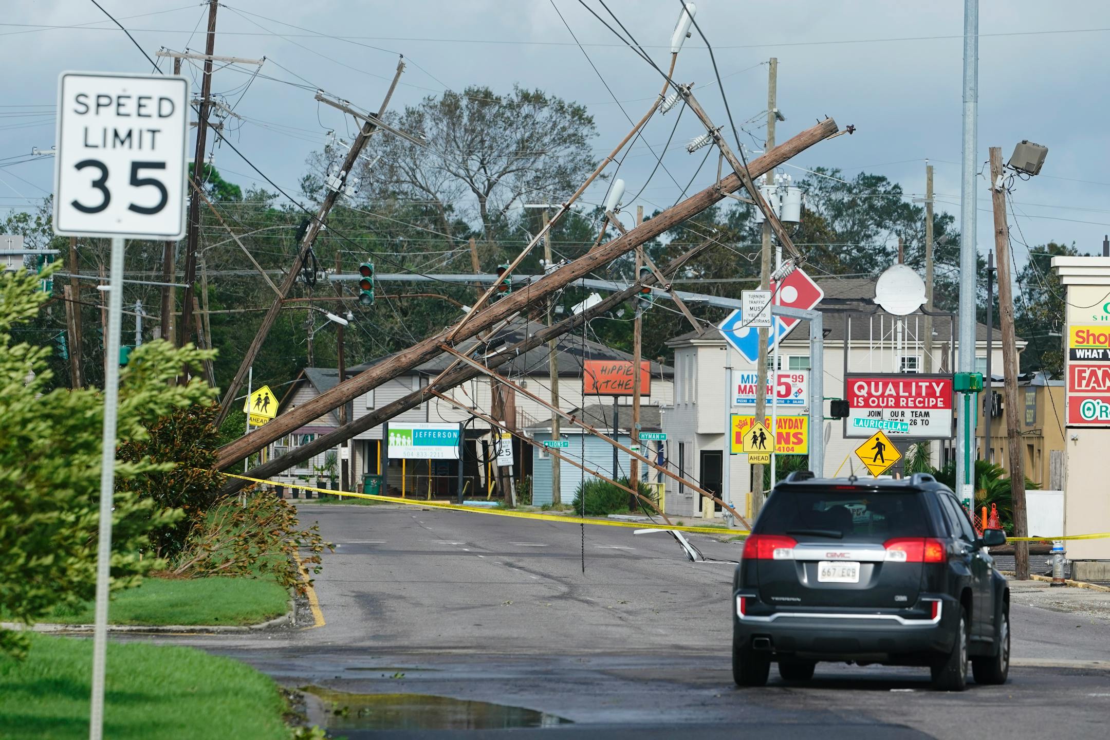 Traffic diverts around downed power lines Monday, Aug. 30, 2021, in Metairie, La. A fearsome Hurricane Ida has left scores of coastal Louisiana residents trapped by floodwaters and pleading to be rescued, while making a shambles of the electrical grid across a wide swath of the state in the sweltering, late-summer heat. One of the most powerful hurricanes ever to hit the U.S. mainland has now weakened into a tropical storm as it pushes inland over Mississippi with torrential rain and shrieking winds. (AP Photo/Steve Helber)
