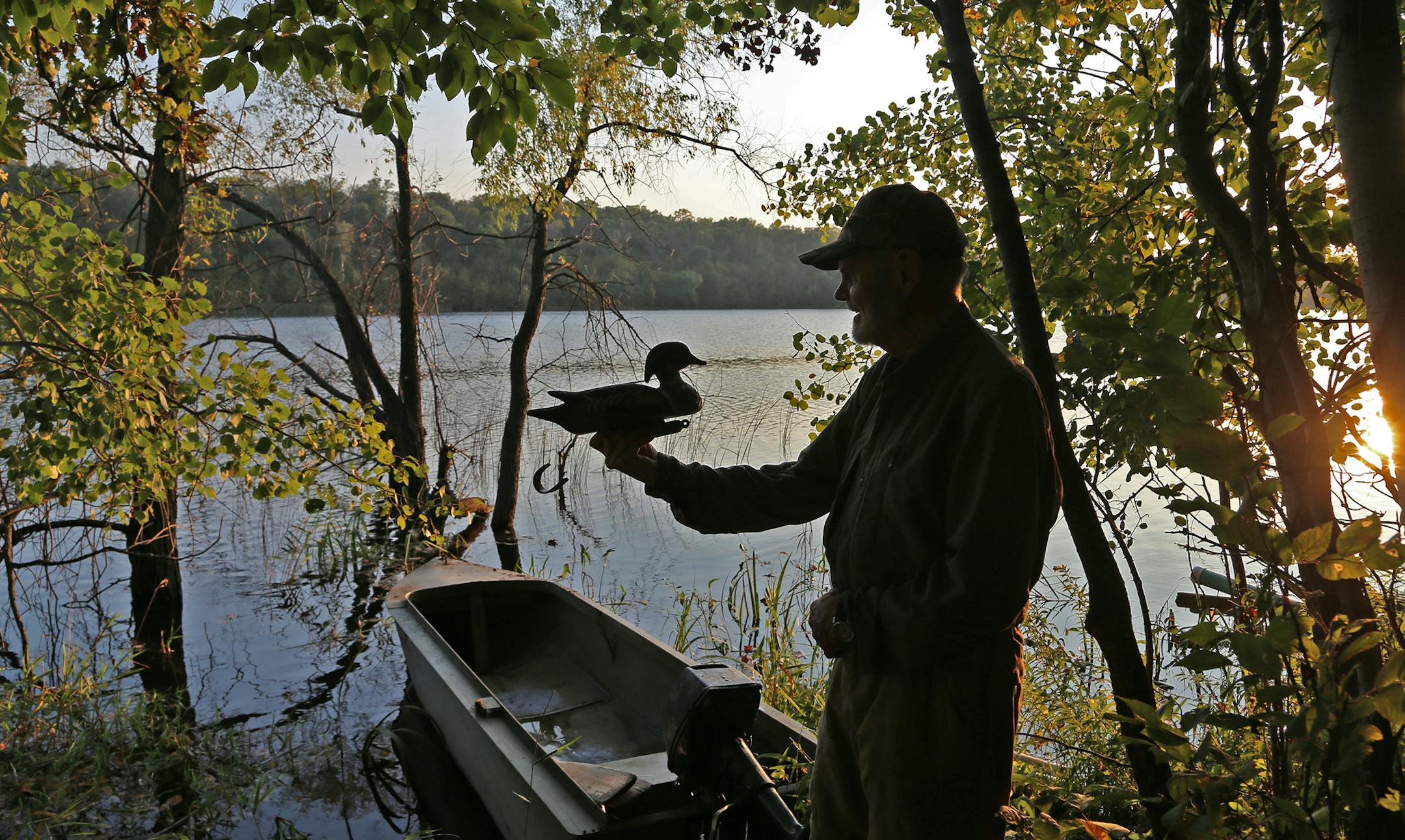 With a vintage Lund Ducker boat in the background, Roger Strand checks out a wood-duck decoy on the eve of Saturday's duck opener. Strand, of New London, a retired surgeon, has nearly 100 wood duck boxes on his farm. The Strand farm also serves as the site of the annual Prairie Pothole Day, a sort of mini Game Fair that promotes conservation and fall sporting interests.