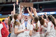 Benilde-St. Margaret's standout Olivia Olson hefts the Class 3A trophy surrounded by her teammates after Saturday's victory over DeLaSalle at Williams